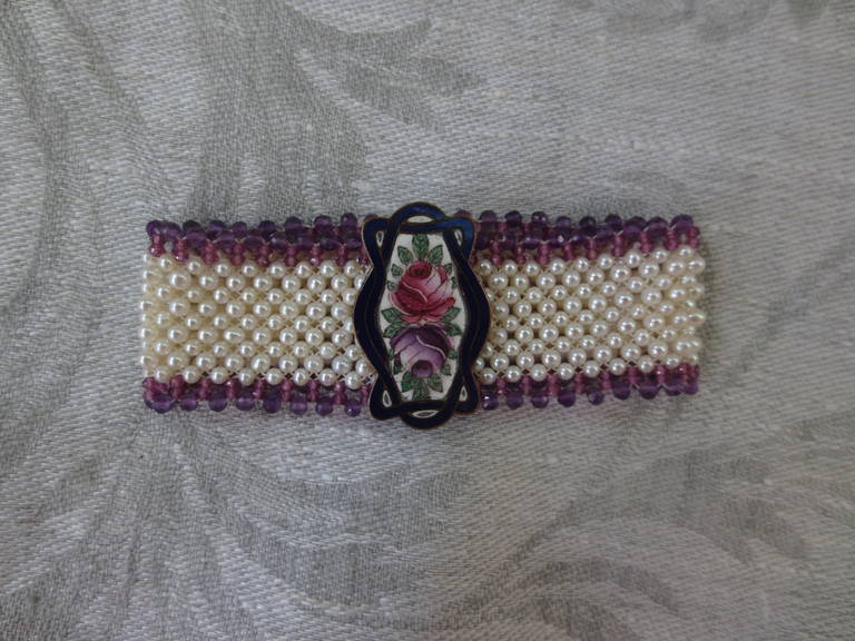 Beautiful and delicate enamel brooch is redesigned as the centerpiece on this bracelet. Tiny 2 mm pearls are delicately hand-woven with 1-2 mm garnet and amethyst faceted beads creating a design and artistry reminiscent of a bygone era. The pearls