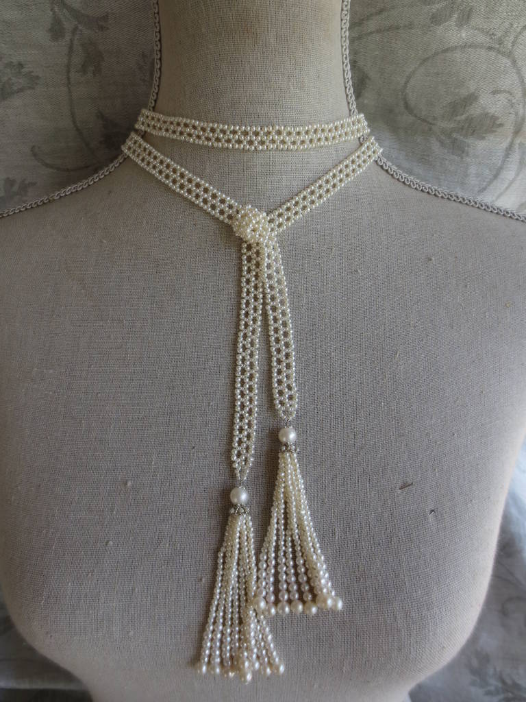 One of a kind handmade sautoir made of fine white pearls. The necklace is hand woven with 1 mm seed pearls into a delicate lace-like design. The ends of the necklace taper to white gold and pearl detail accents leading up to the beautiful tassels on