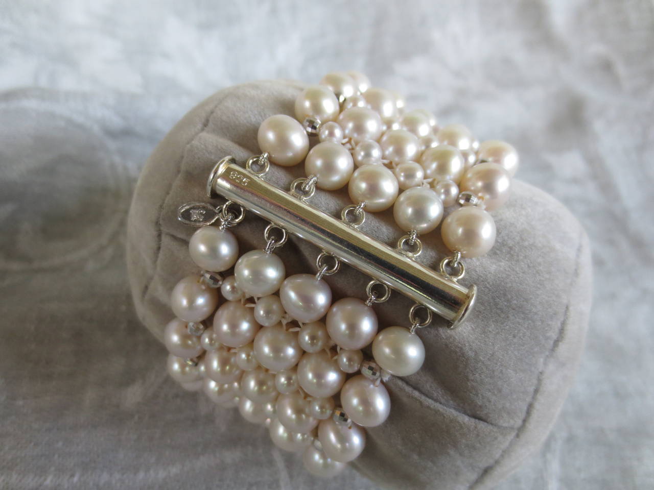 Intricately hand woven cultured white pearl bracelet is made using 6mm and 3mm in size. The outer rows are accented with sterling silver faceted beads giving the bracelet  Bracelet measures 7 