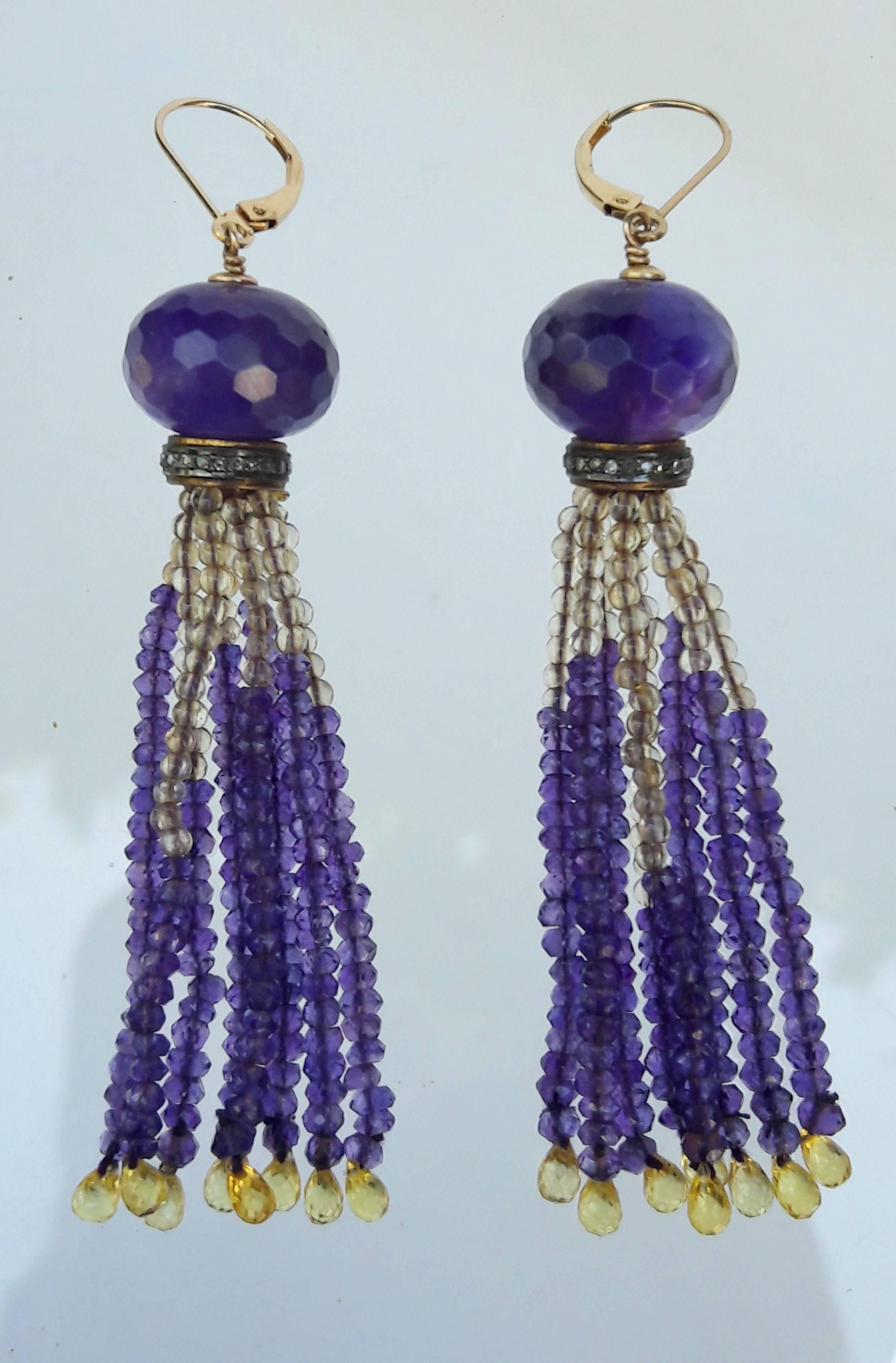 Strands are made of faceted amethyst and round citrine beads measuring approximately 2 mm each. Each strand tapers with a delicate and fine citrine briolette. The tassel strands hang from a detailed 14 k gold, silver and diamond rondelle topped with