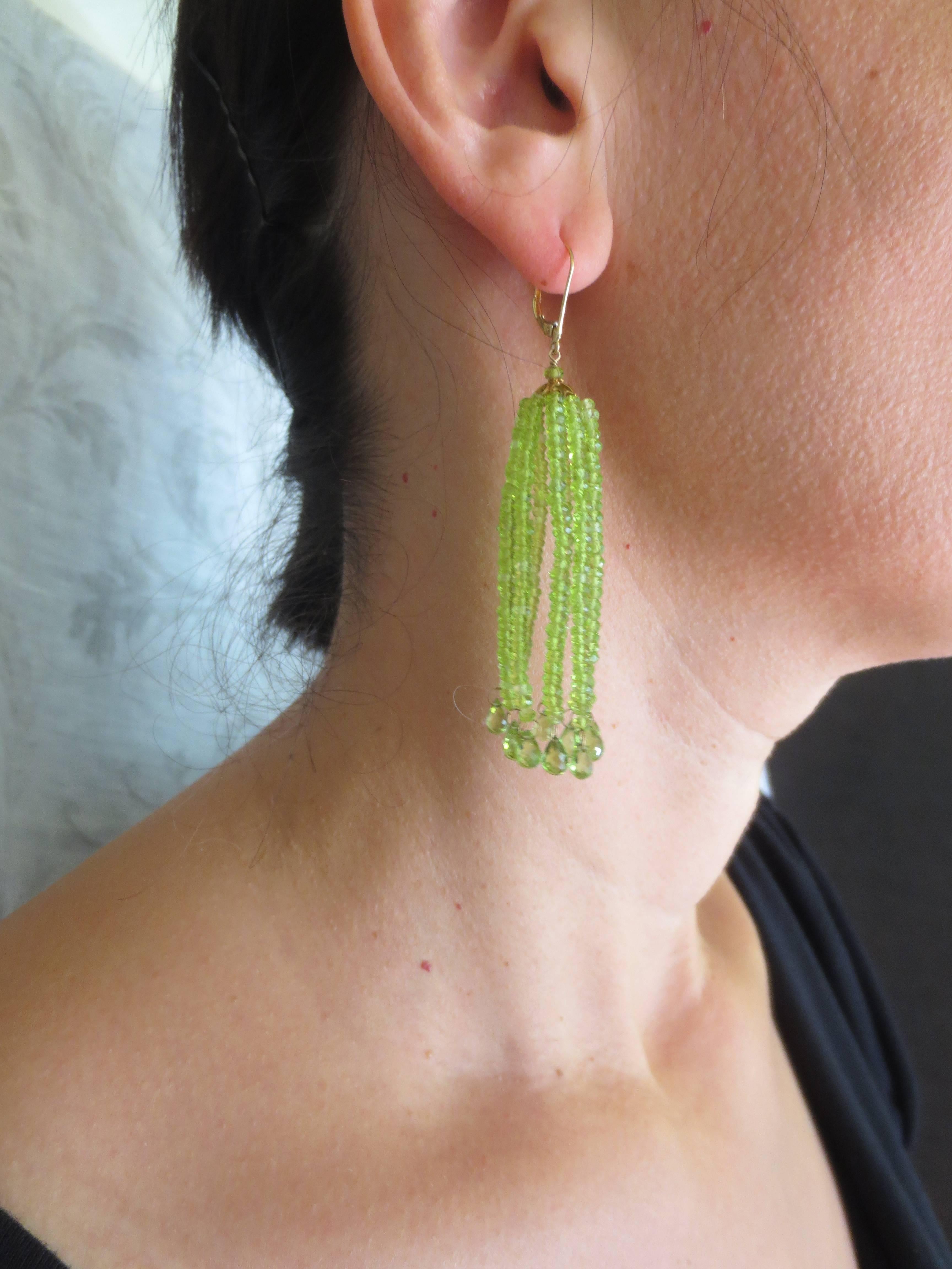 These beautifully crafted tassel earrings are made of faceted 1.5mm - 2mm peridot beads. Each string ends with fine peridot briolettes, hung by 18K gold hoops, offering a light and lush feel. The tassel hangs from an 18k filigree gold cup. Ear wires