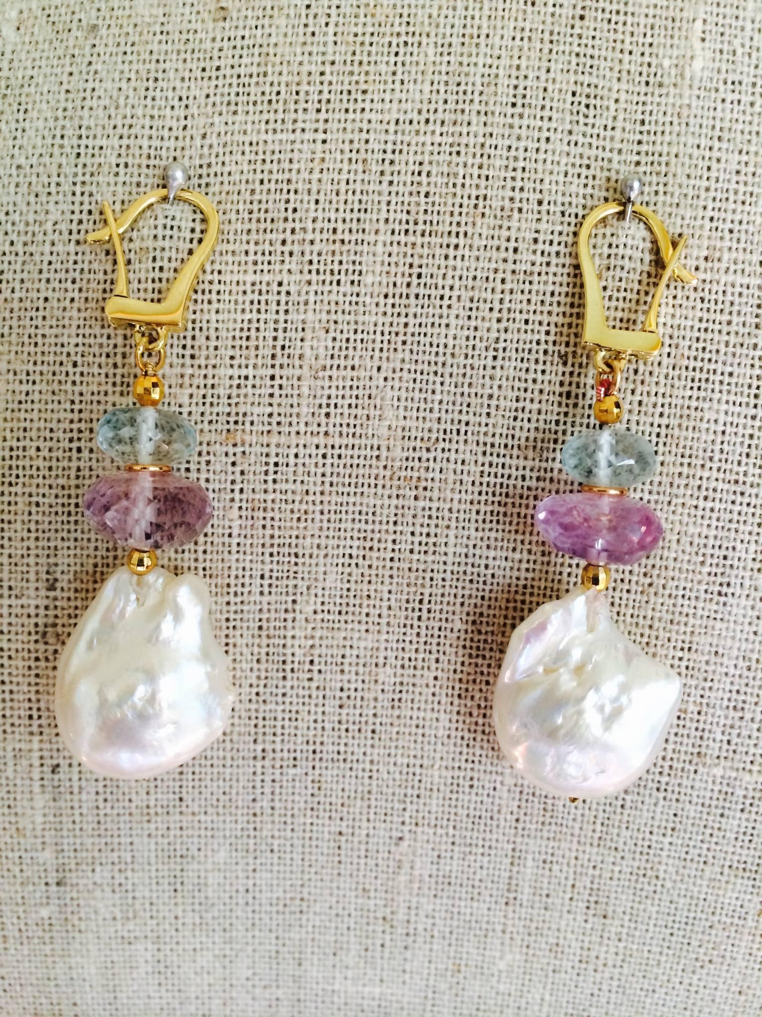 Aquamarine and Amethyst roundels beads are punctuated with 14k gold beads and sit atop a large, eccentric baroque pearl. Secured with a 14k yellow gold hook, the pearl dangles and moves freely with every step. Elegant and playful. Pairs best with