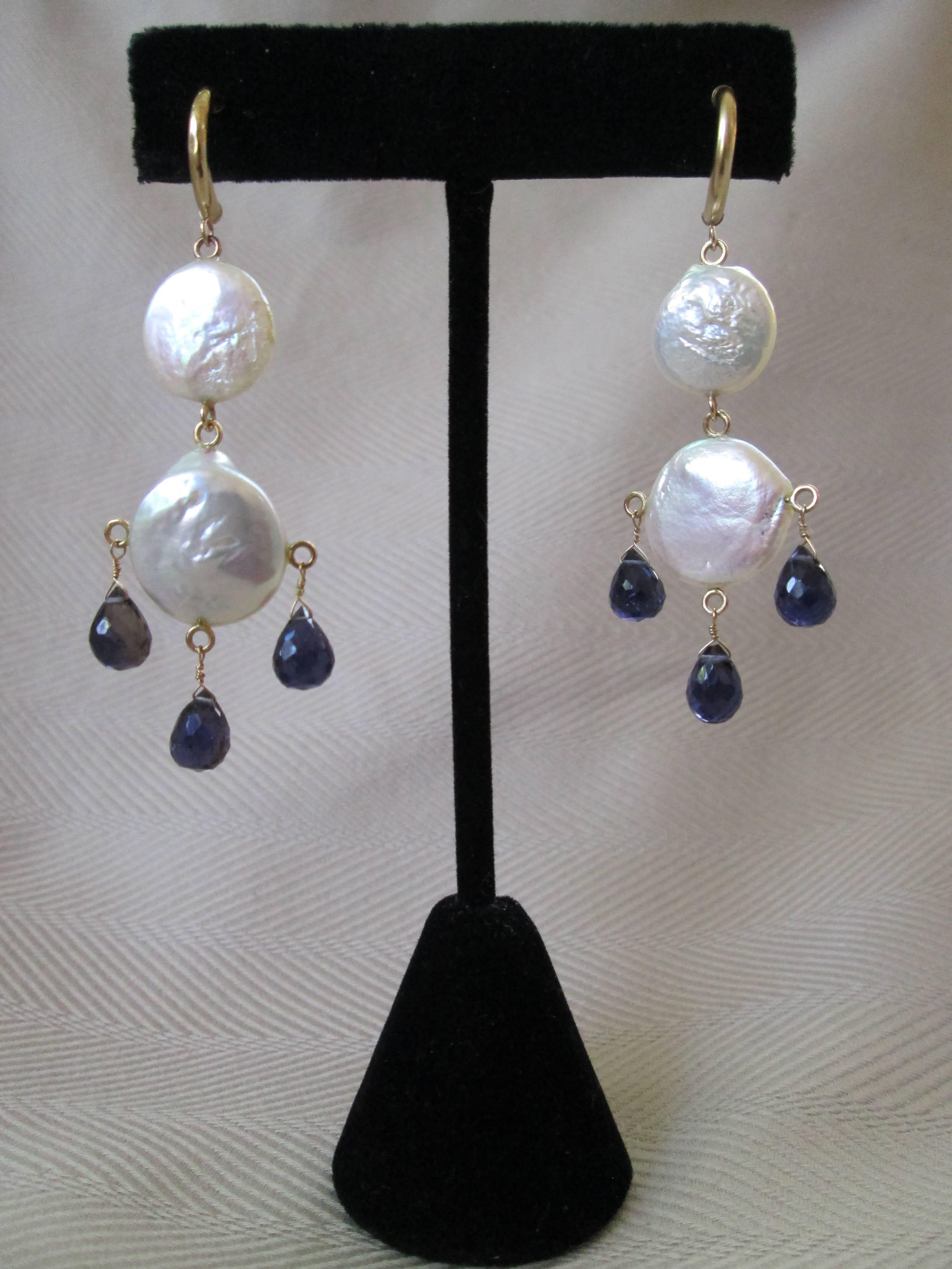 Flat coin Pearls, and Iolite Briolettes are connected by 14K Yellow Gold findings and combine to create a pair of distinct earrings, that sway with your motion. Earrings measure 2 1/4