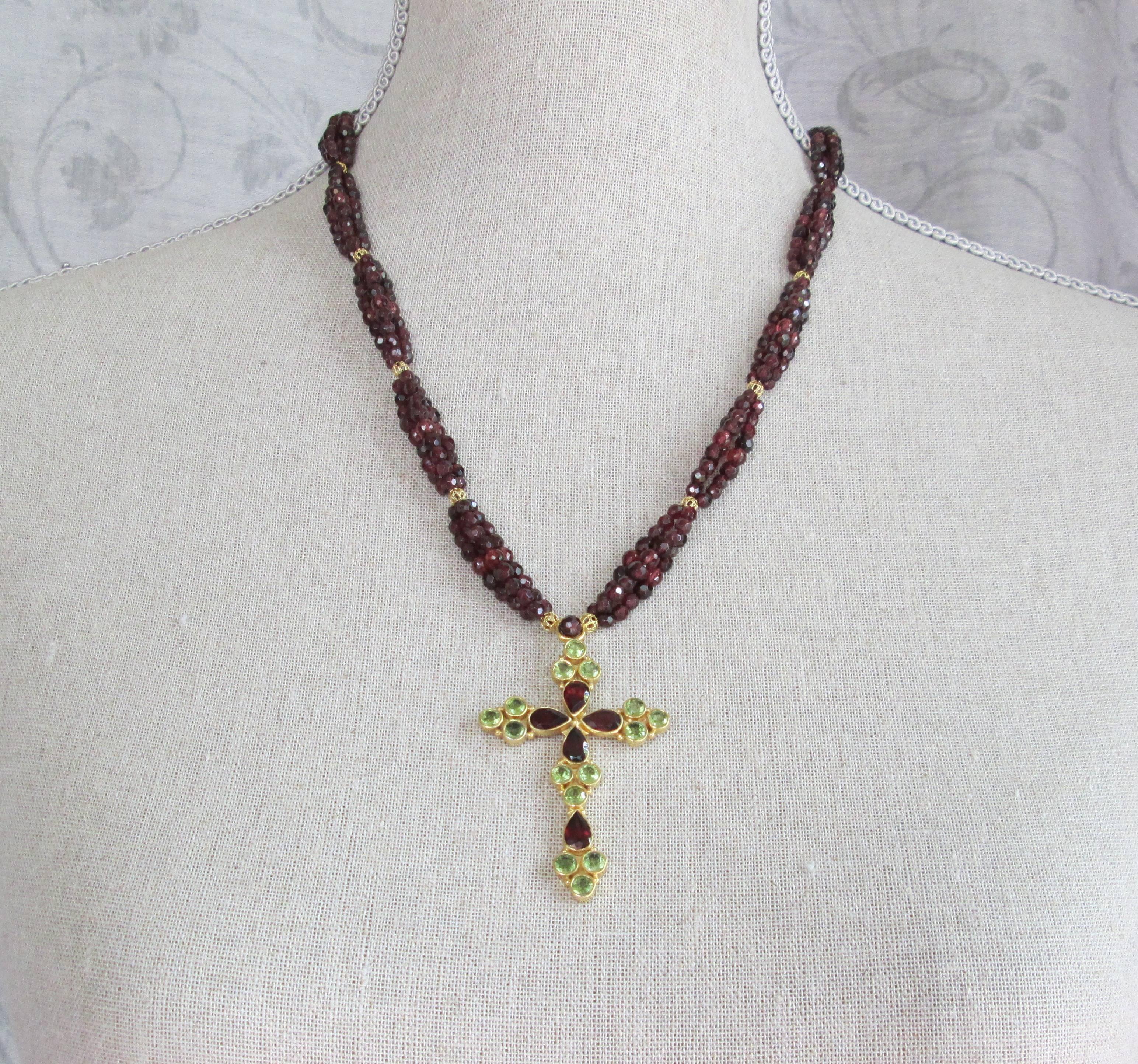 This striking necklace features strands of faceted garnet beads (3-3.5mm) clustered in threes, and divided by gold over silver plated vintage filigree beads. The cross is exquisitely cast in silver with gold plating, and set with precisely cut