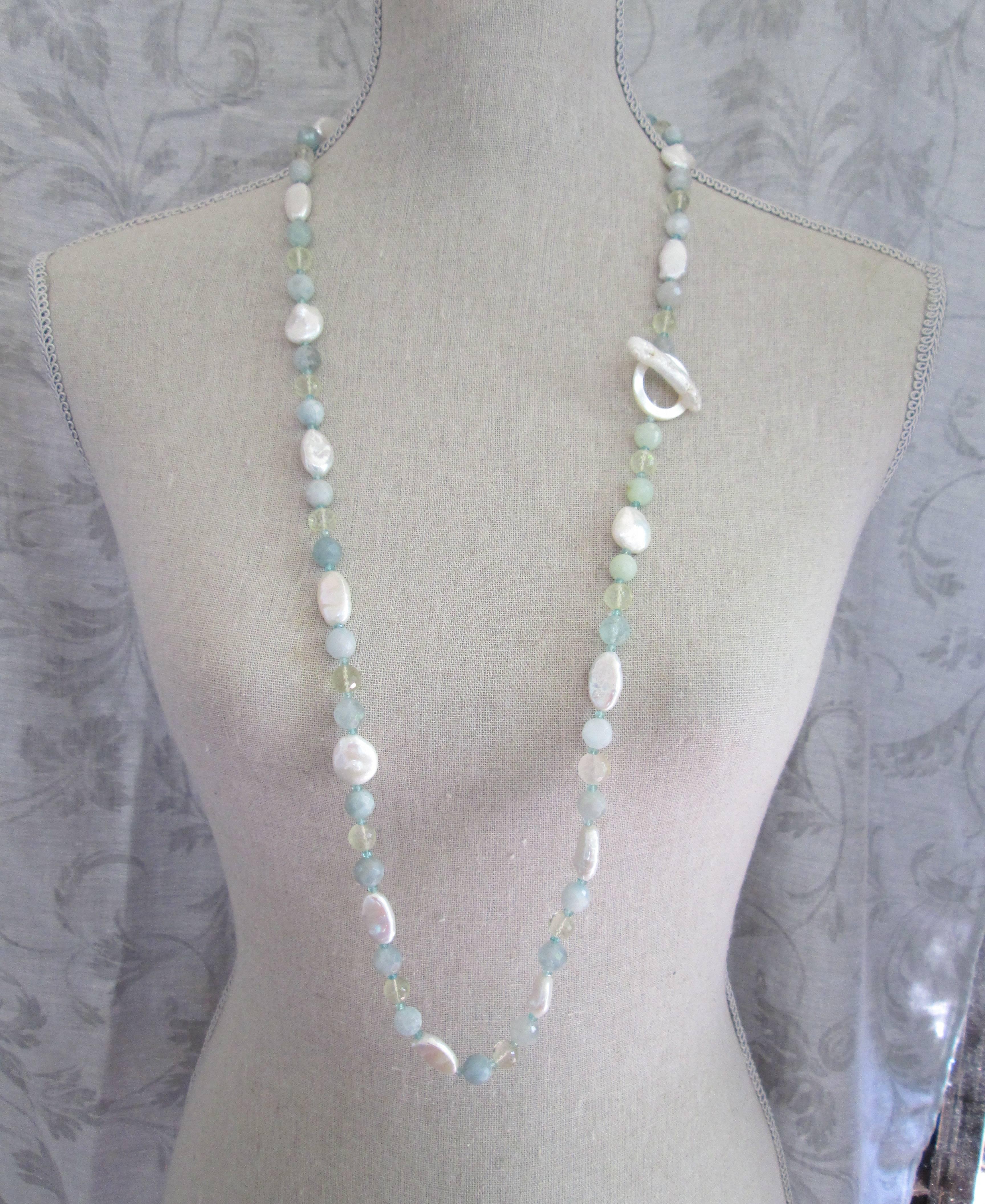 This gorgeous lariat necklace features pearls, aquamarine, citrine, green quartz, florite, and mother of pearl. Each stone is specifically chosen to create a mixed balanced form on the necklace pattern. Long and versatile, it can be worn open or