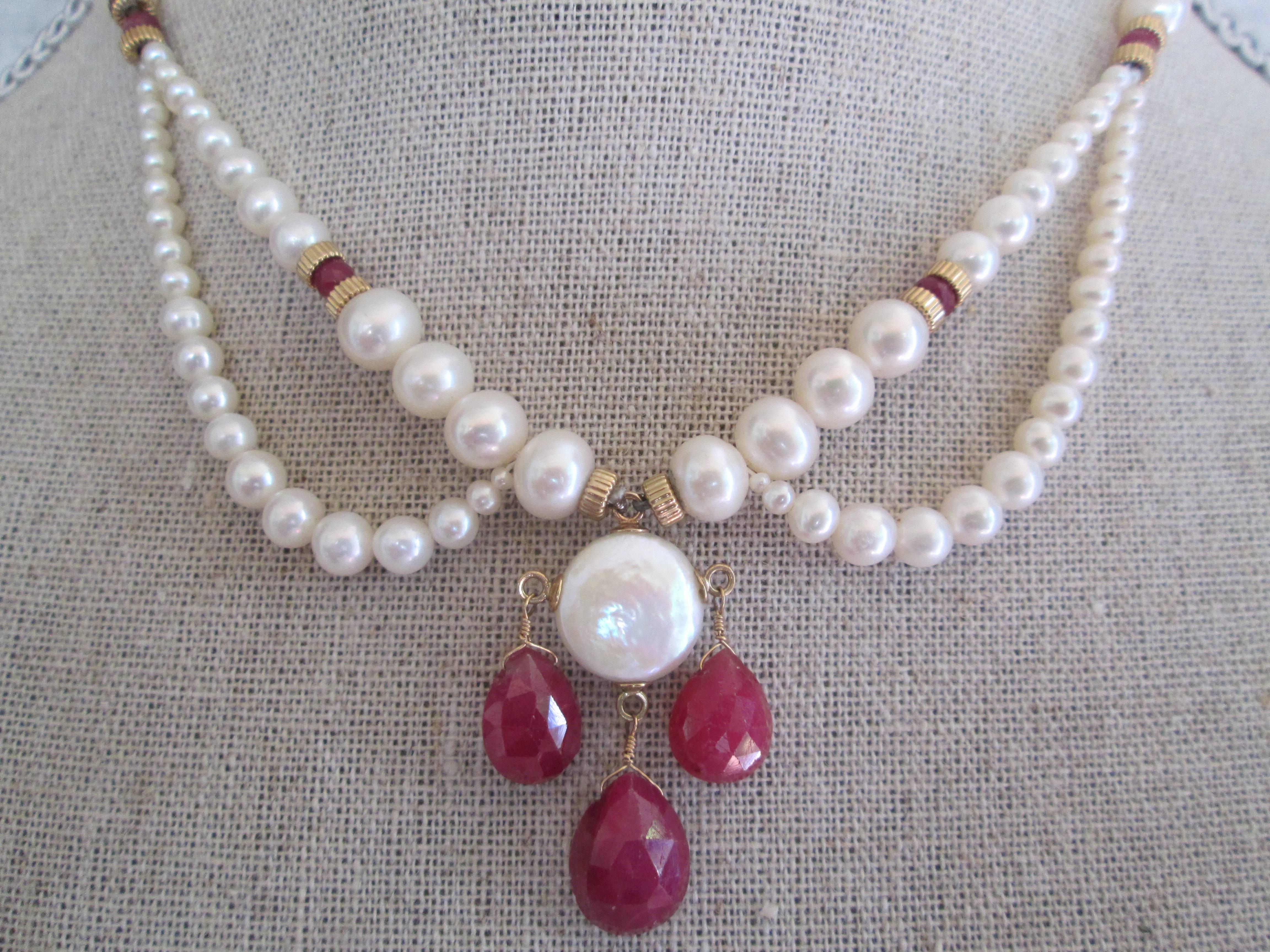 Uniquely graduated pearl necklace with ruby briolettes attached with 14k yellow gold findings, beads, and clasp. Centerpiece his highlighted by round, coin pearl. Lightweight, and graceful. Great for weddings, graduations, and other formal