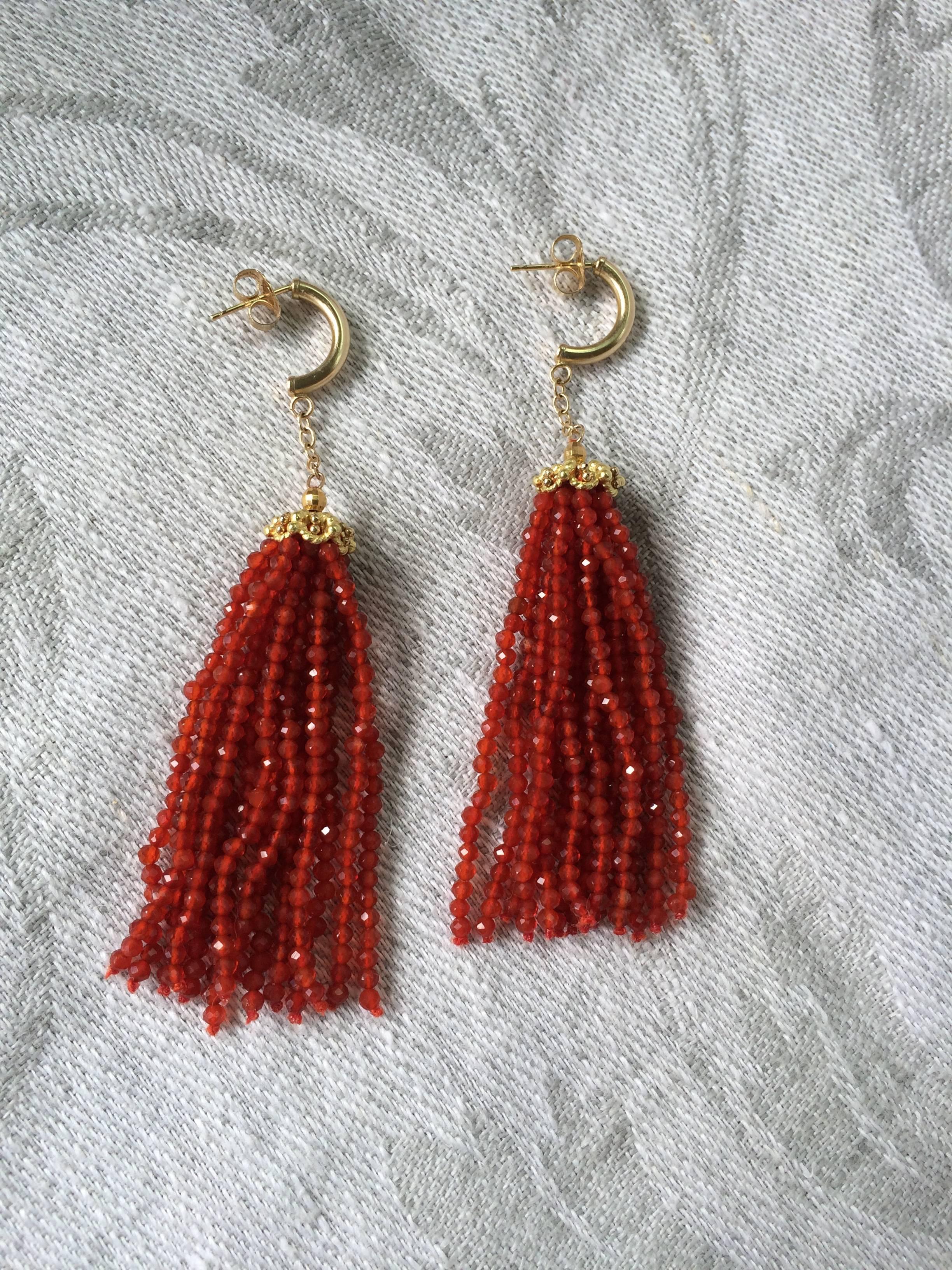 Very fine ( in size and quality) faceted carnelian beads are grouped together into tassels and dangle from a 14 k yellow gold filigree cap. Suspended from a gold chain, the earrings move and dance with every step. Fun, yet refined. Great for