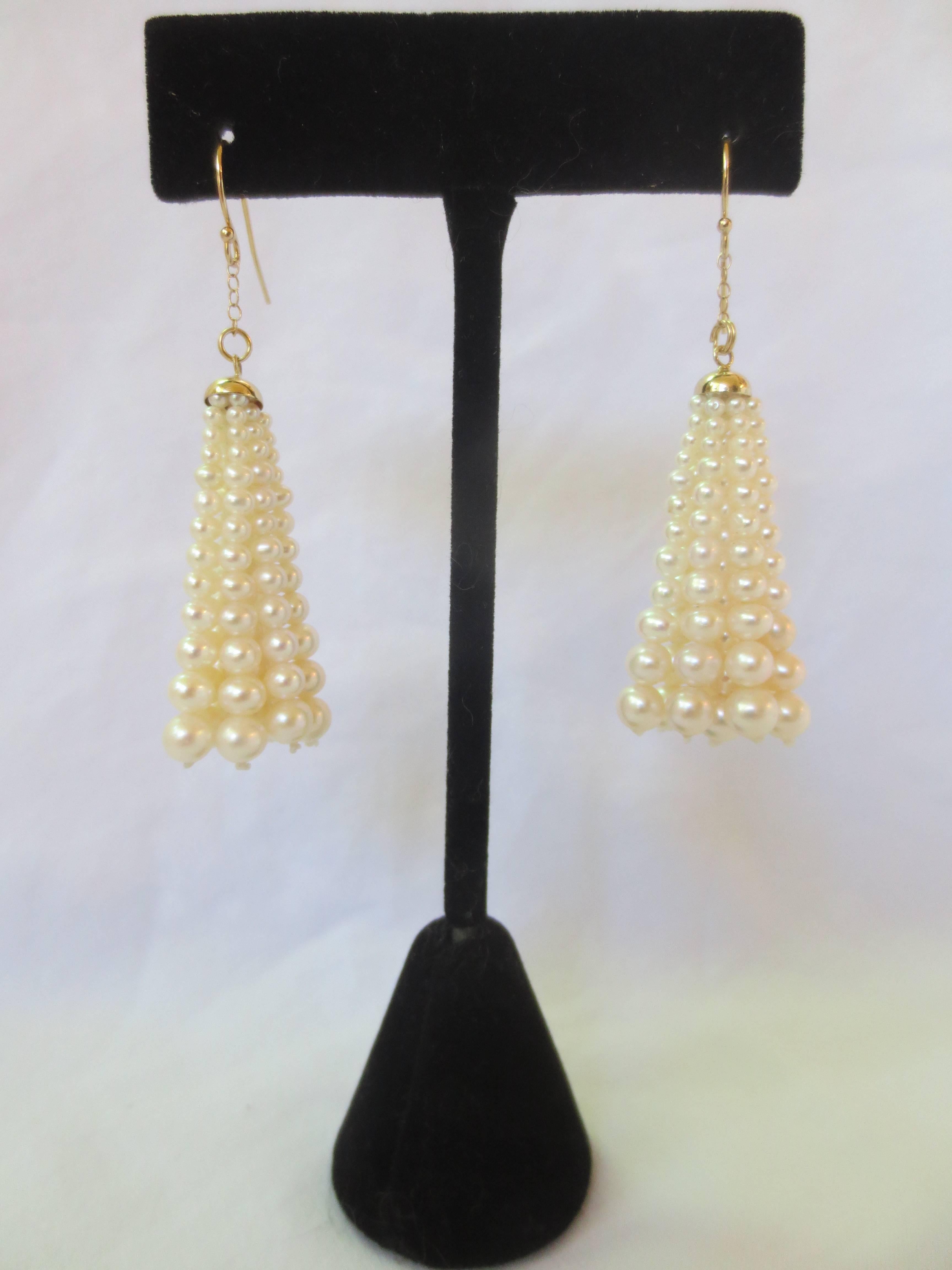 Strands of pearls, (eight strands each) graduated in size from 1 mm to 4 mm emanate from a 14 k yellow gold cup. The pearls and cup dangle from a gold wire, and dance with every step. The earrings with wires measure 2.5 inches, and tassels alone are