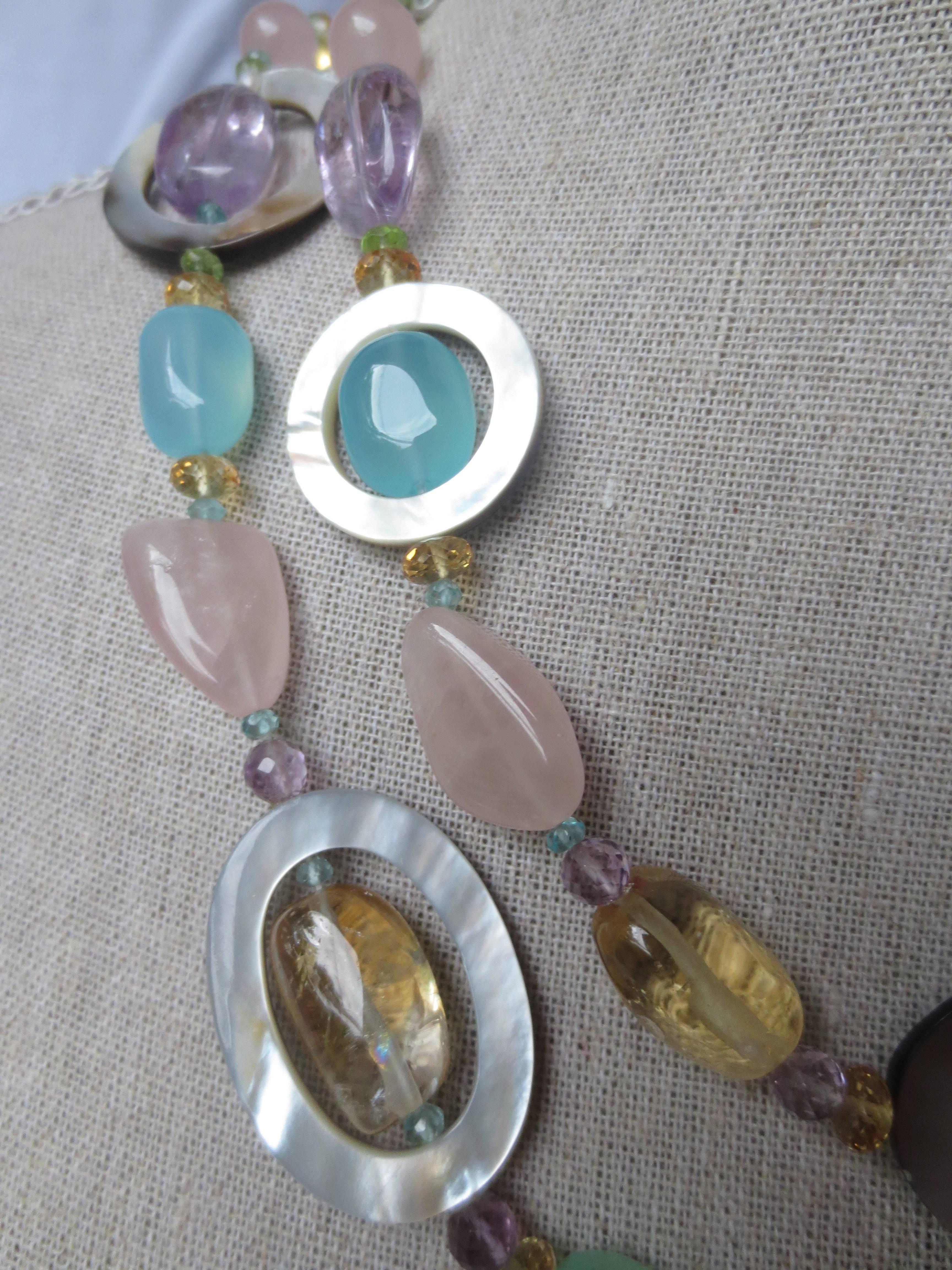  Amethyst, Citrine, Aquamarine, Peridot, Calcedony, Rose Quartz, and Fluorite beads are combined to create a gorgeous shimmering piece. The semiprecious stones highlight the luster and iridescence of the mother-of-pearl oval and round rings,