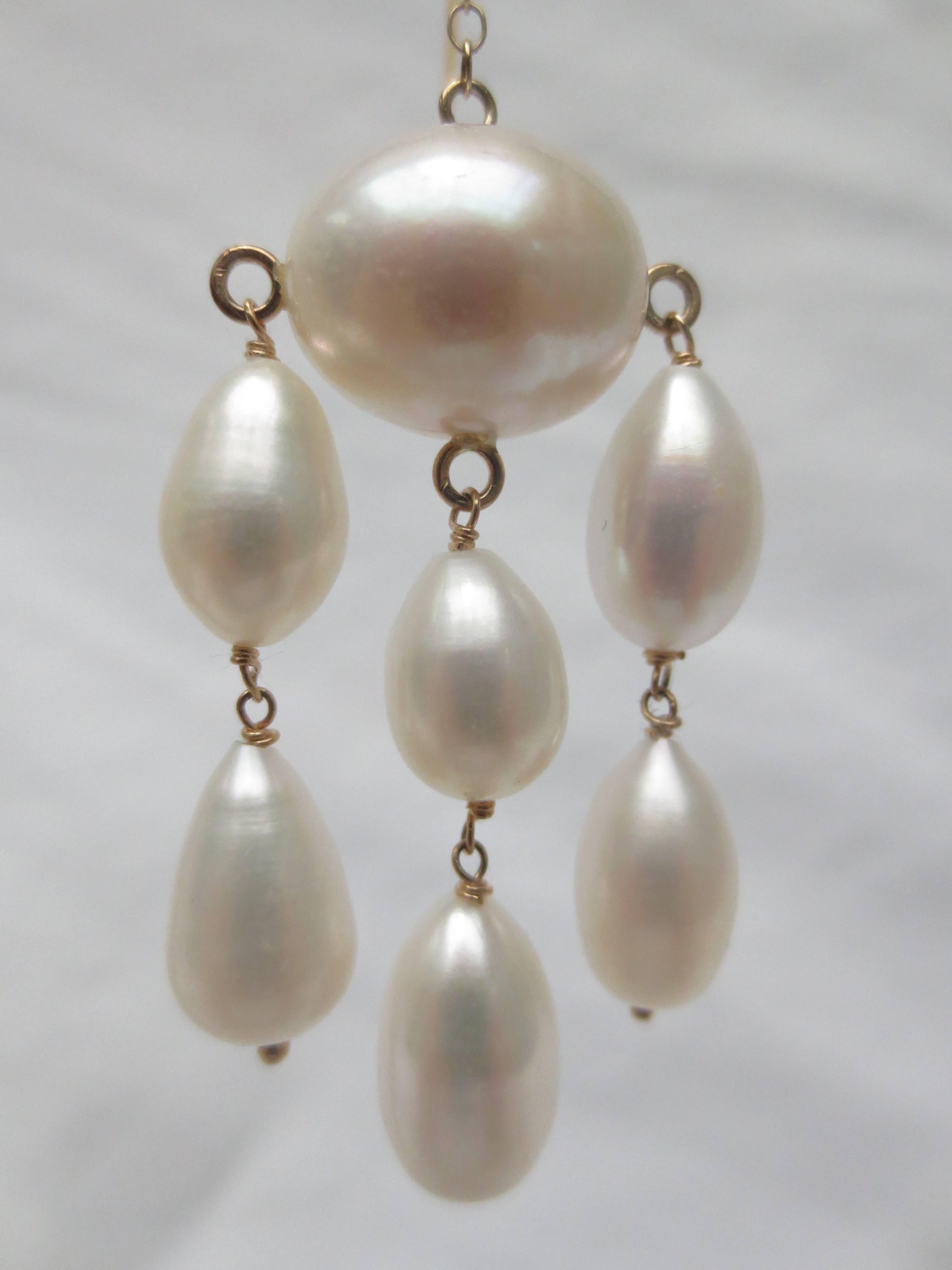 Each earring consists of 6 teardrop baroque pearls hanging from a large oval (11mm W) pearl by 14k yellow gold wire. Large, but not imposing; refined, yet lightweight. The dangling pearls and gold chain make for a lot of movement. Make each step a