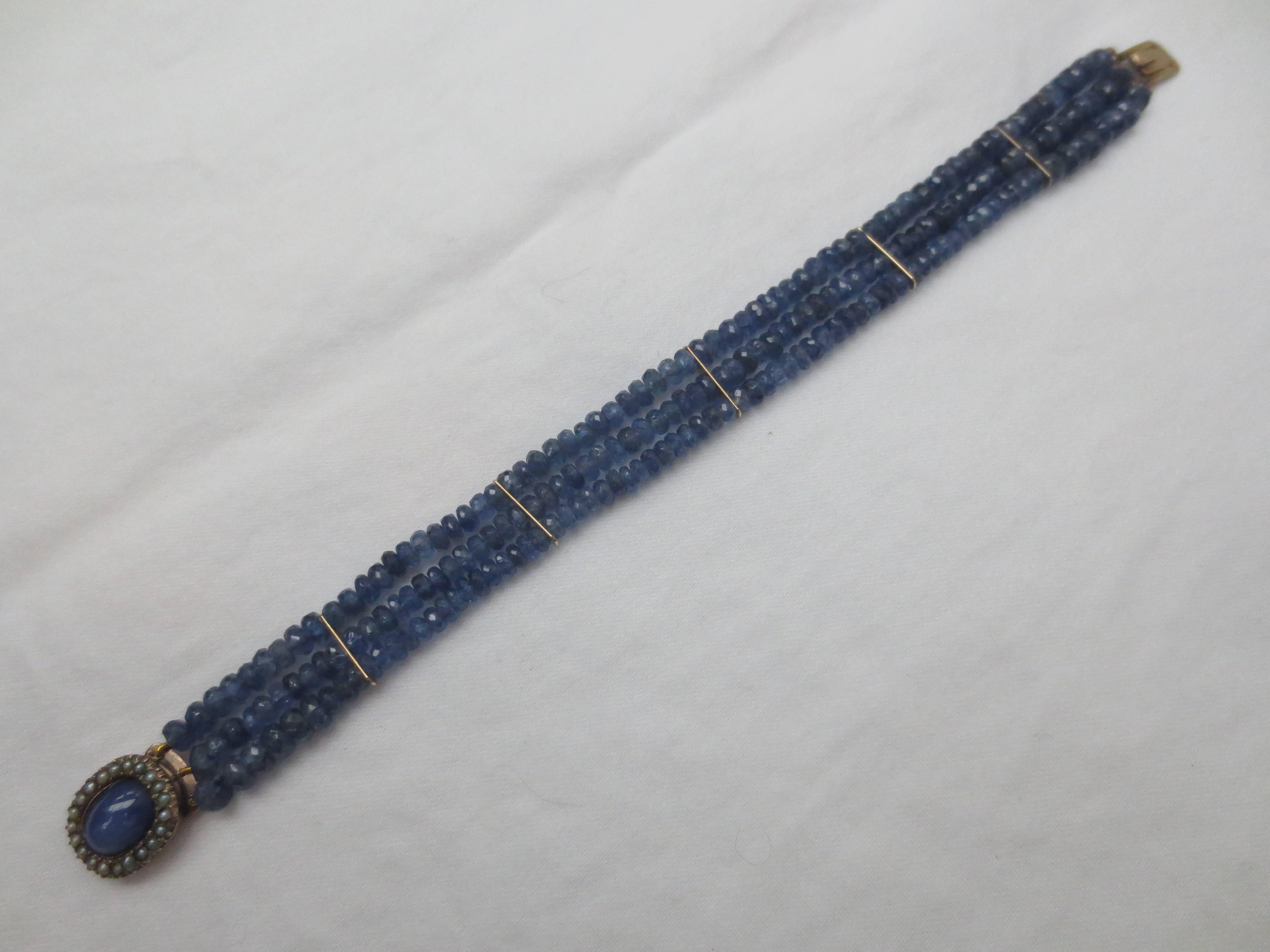 Turn-of-the-century gold and seed-pearl mourning clasp, refitted with 1cm star sapphire stone. The clasp serves and the centerpiece for strands of faceted blue sapphire beads divided by 14 k gold segments. 

Made by Marina J. 2016