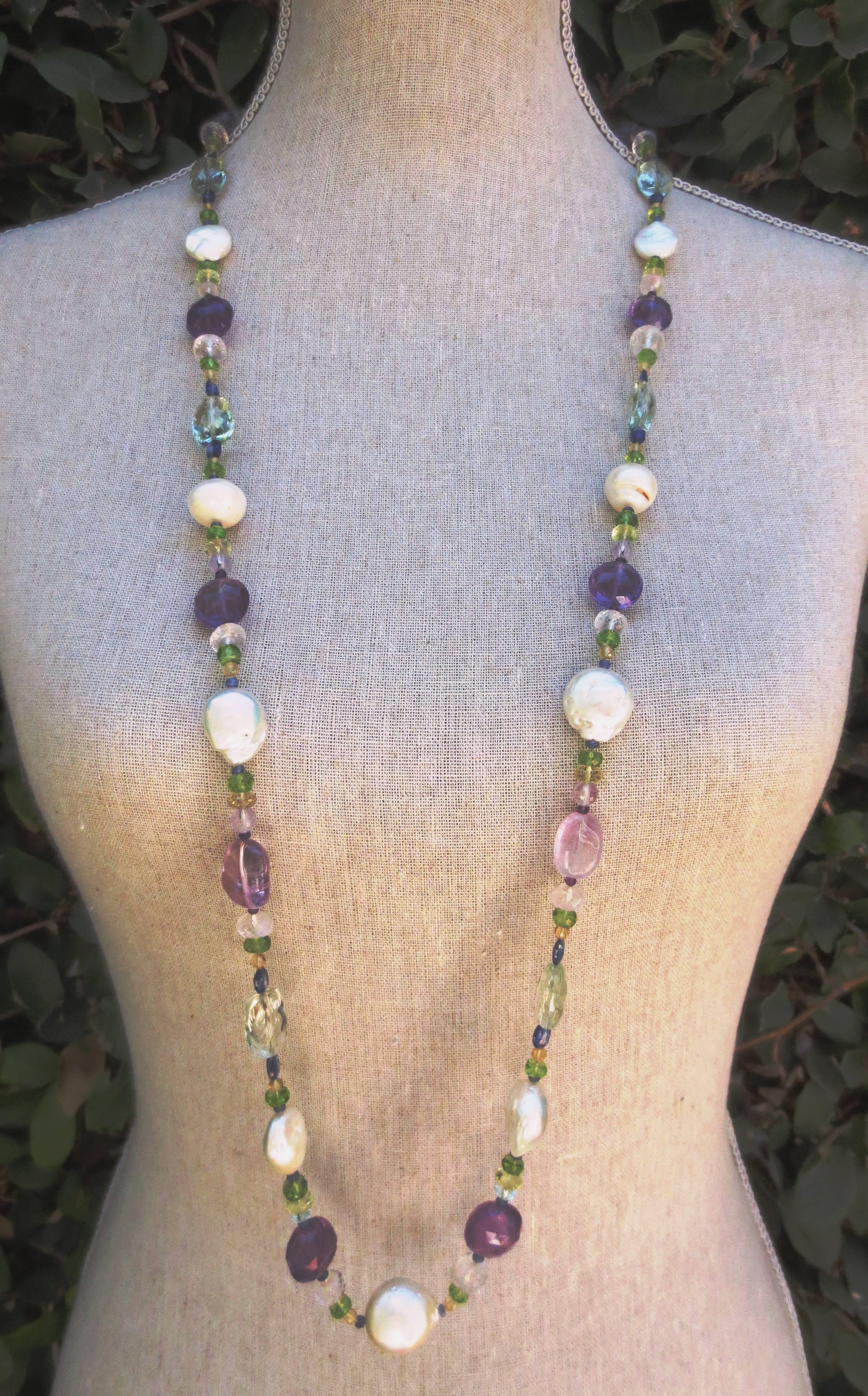 Amethyst, Citrine, Aquamarine, Peridot, Rose Quartz, Iolite, Baroque Pearls, Sapphire, and Garnet beads are combined to create a gorgeous shimmering piece. This stunning necklace can be worn long, or wrapped and is secured with a 14 K Yellow Gold