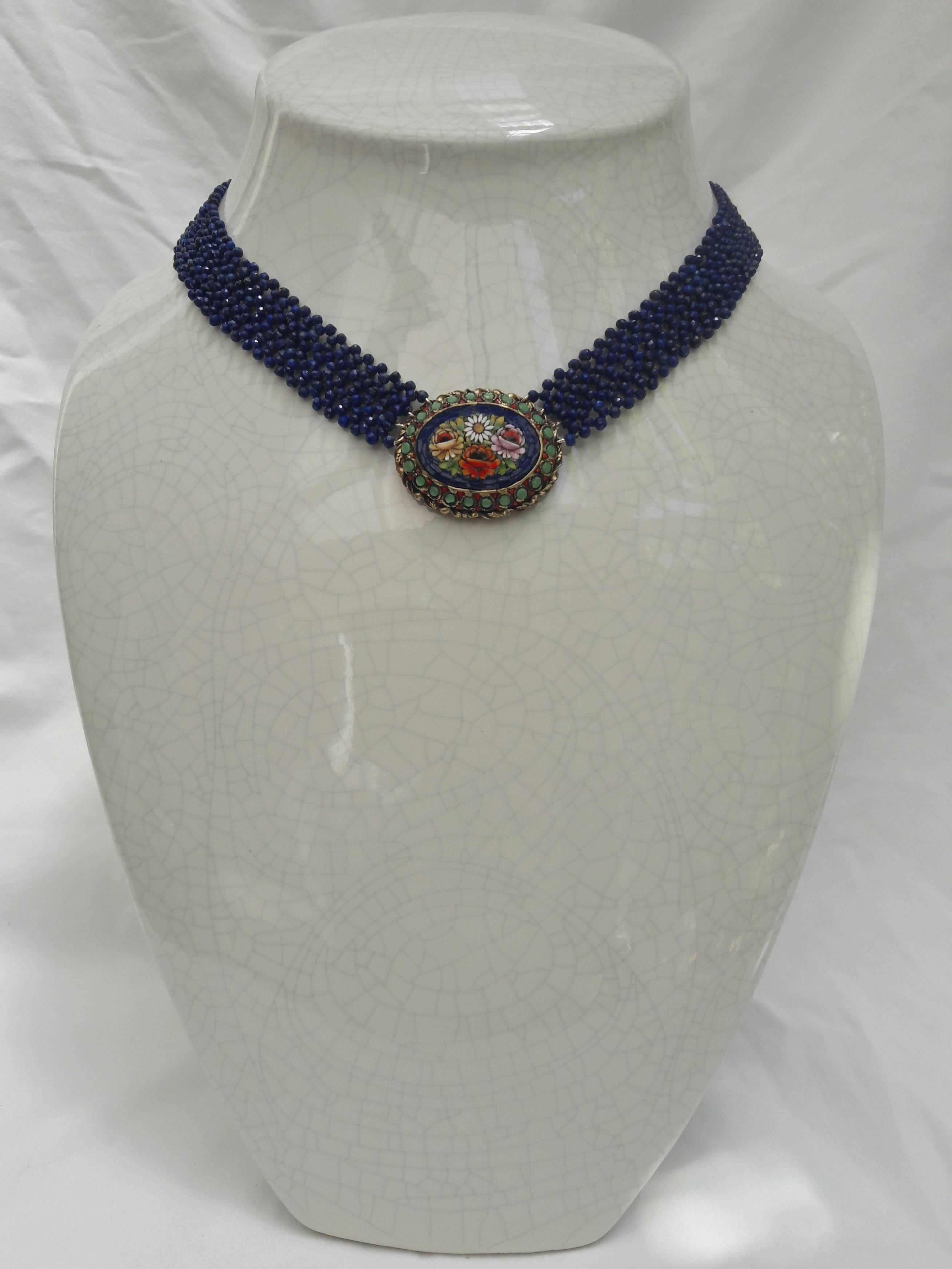 Turn of the century fine and detailed micro mosaic brooch necklace, decorated with a colorful floral still life. The multi-stranded woven lapis-lazuli ribbon looks like it came with the brooch originally. Marina has, very expertly, color matched the