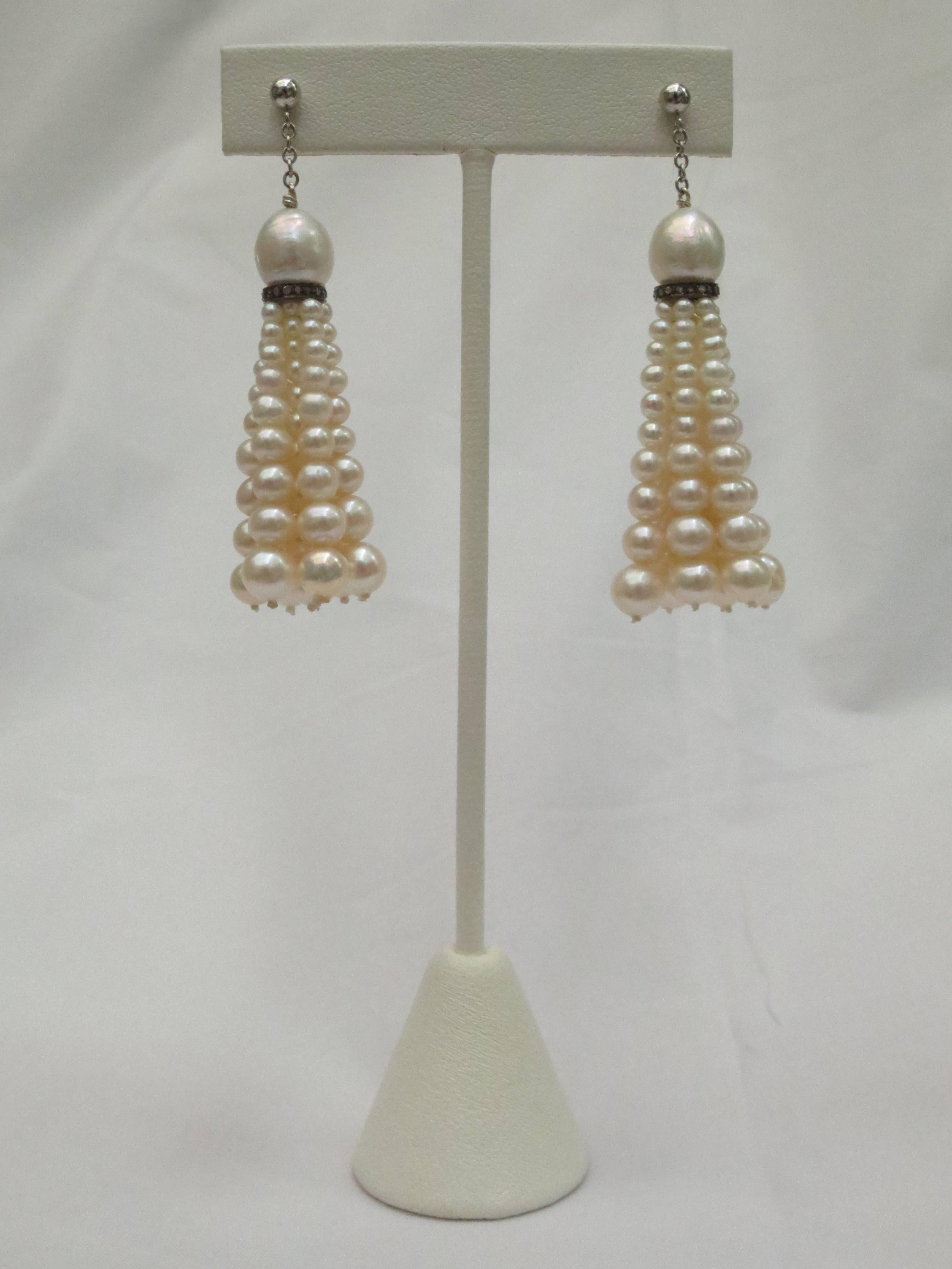 These timeless dangle earrings feature a large 9 mm cultured pearl cup set on a sterling silver and diamond rondelle. The tassels are made of fine graduated cultured pearls. Ear-stud is 14k white gold followed by a white gold chain for free