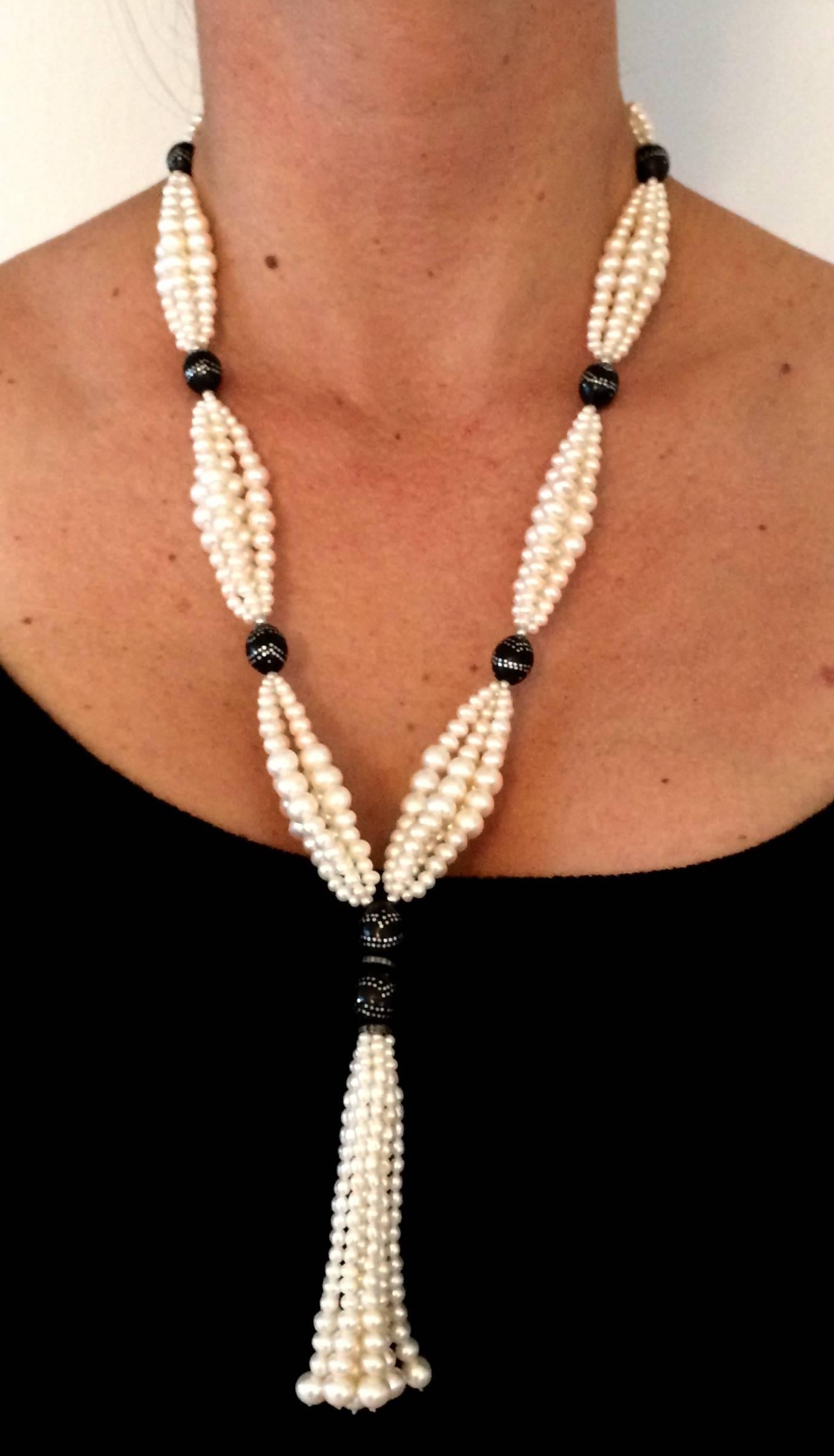 This elegant sautoir features double graduated white pearl clusters strung between  wooded beads detailed with silver inlay. The contrast between the white pearls and the dark wood beads is highlighted by fine 14 k white gold beads.  Tassel measures