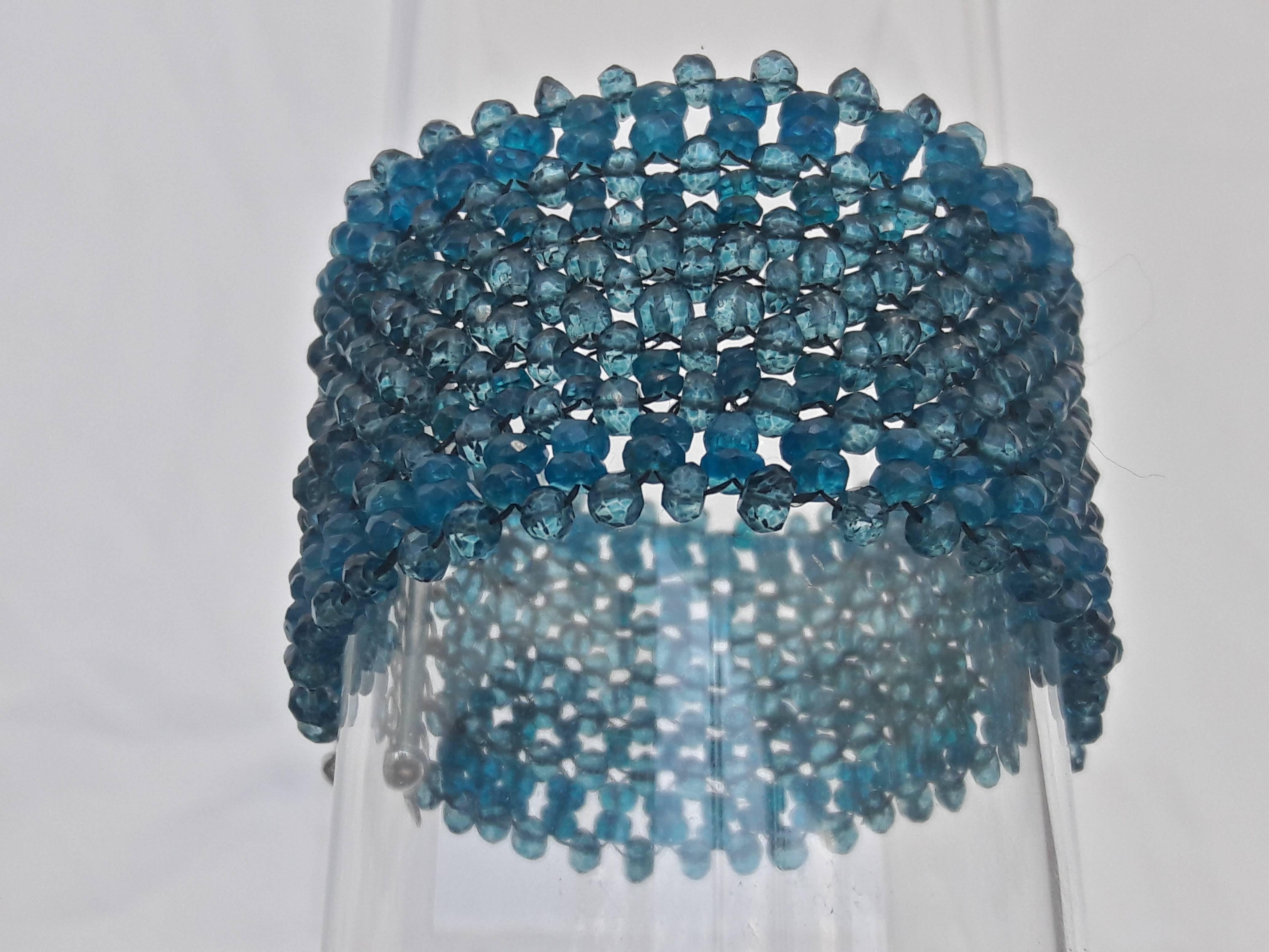 Vibrant, lush, and cool. This bracelet is composed by tightly weaving a multi-strand ribbon of small faceted semi-precious beads. The London Blue Topaz center band is highlighted and framed by the faceted Apatite beads running along the edges.