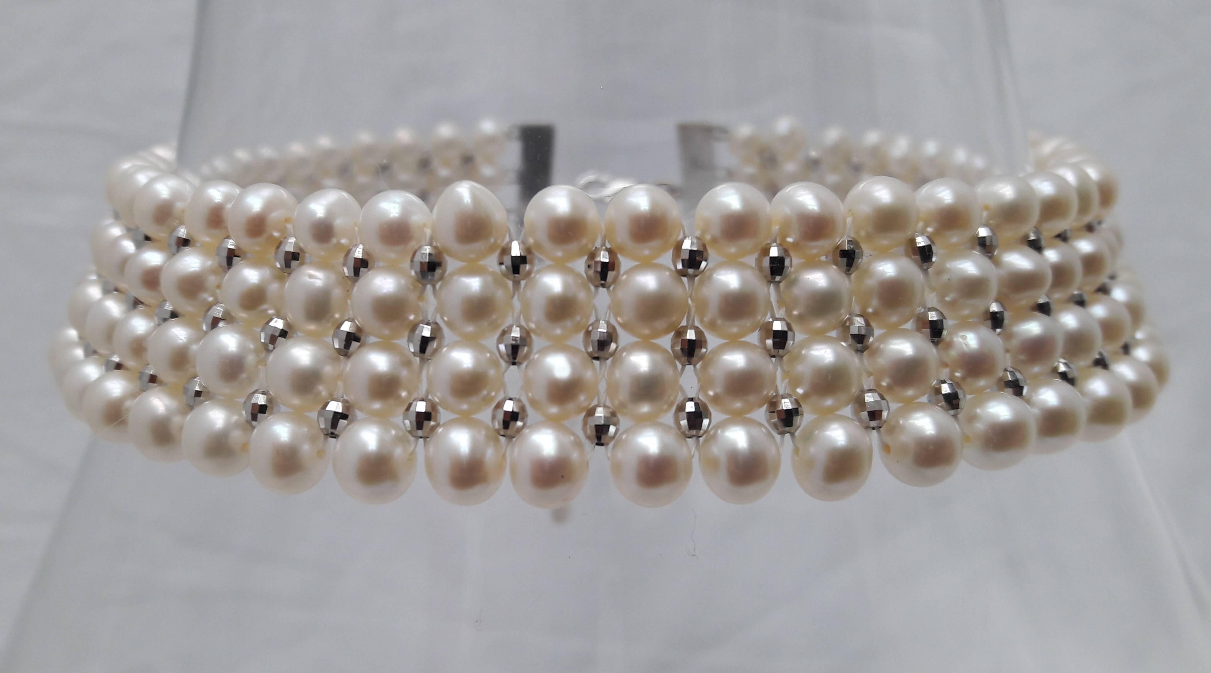 This intricately hand woven choker is made of  4 mm & 5 mm pearls with 14 k white gold-plated silver faceted beads. The use of graduated sized pearls allows for natural curvature in design to fit along the form of the neckline. 

Clasp is made