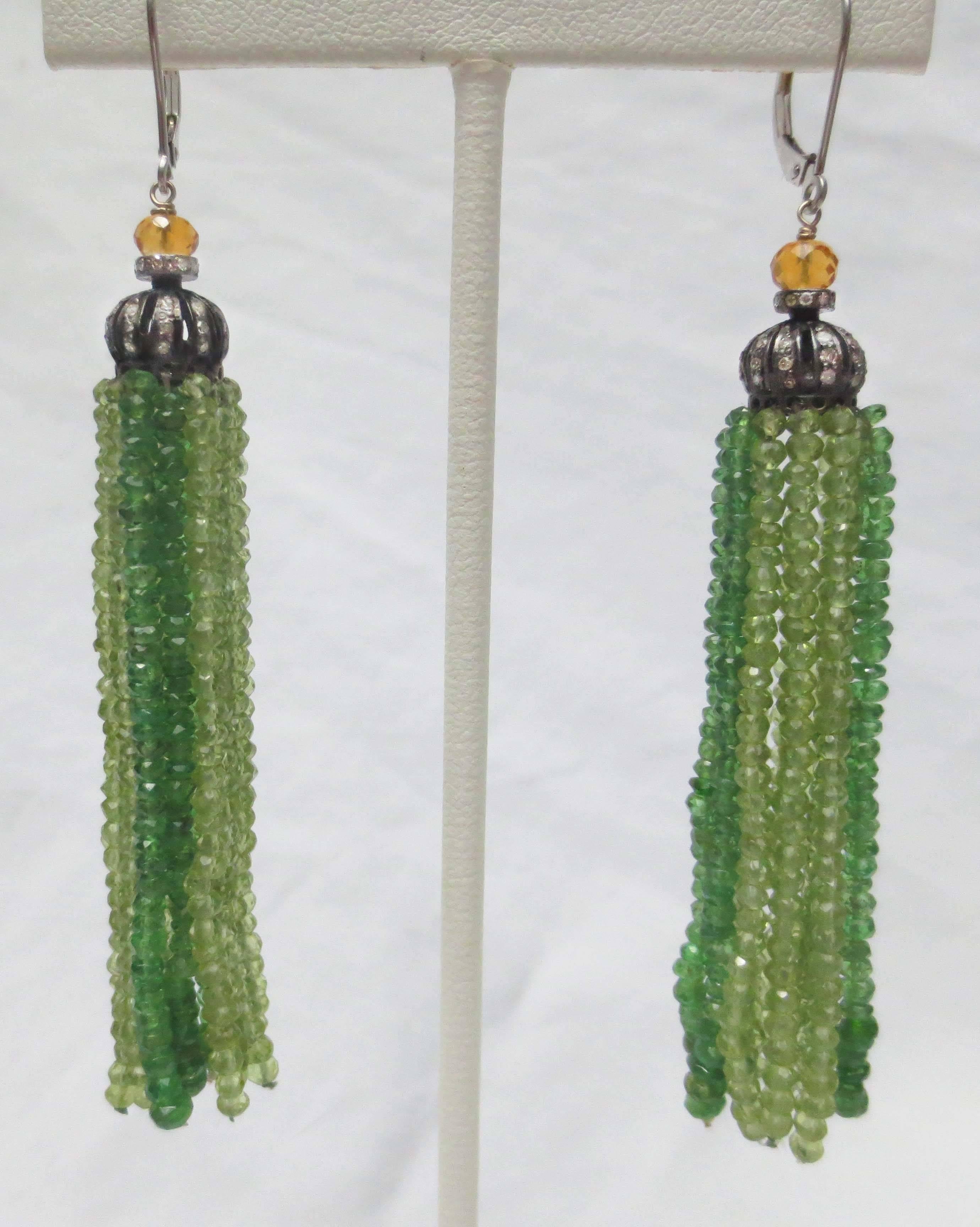 This beautiful pair of tassel earrings composed of diamond encrusted sterling silver cups and finished with gorgeous tsavorite and peridot faceted beads. Ear wire is 14k white gold. At the top of the silver cup are faceted citrine beads that accent