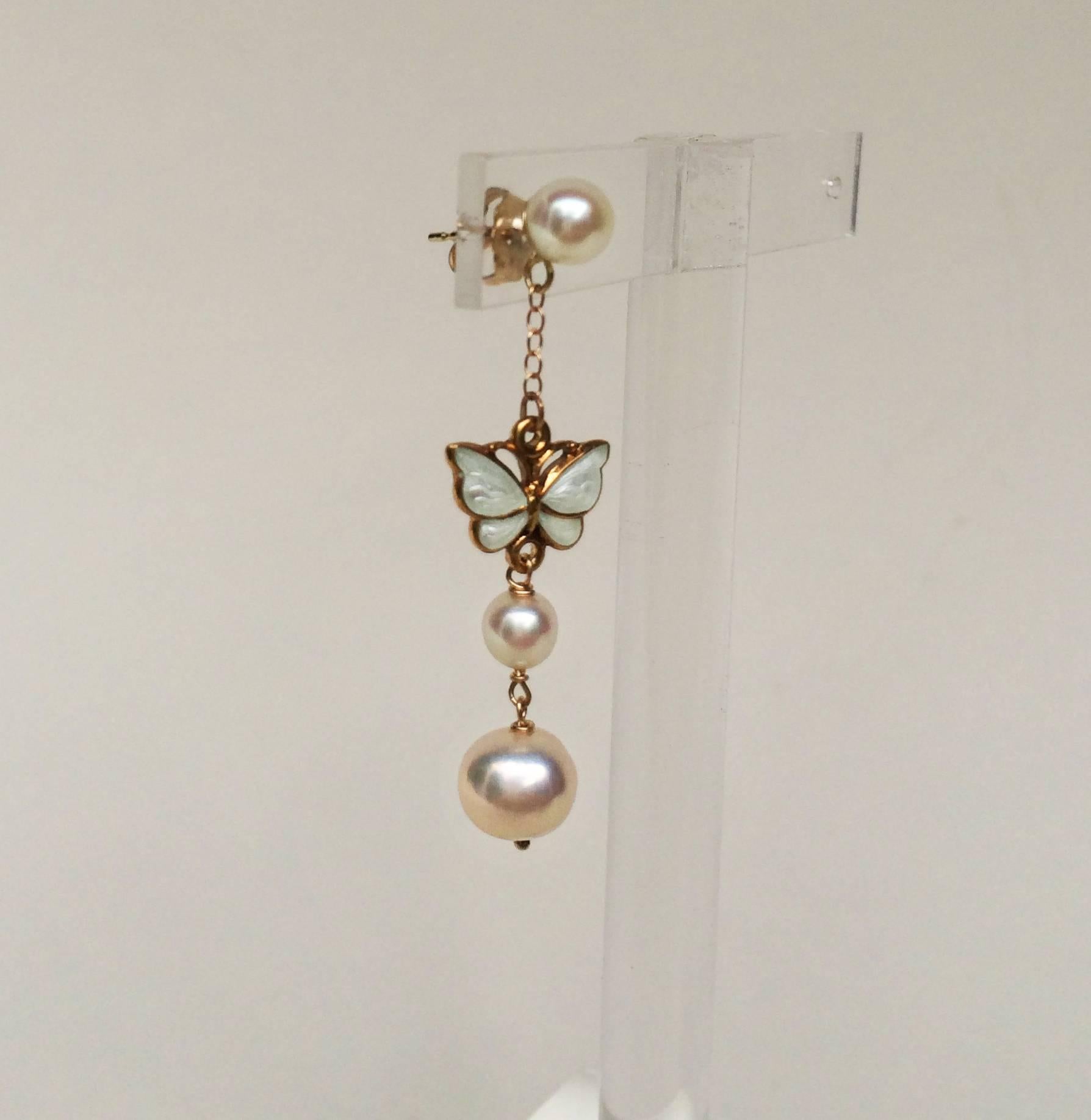 These earrings are perfect for a beautiful day out. A vintage butterfly (c.1950s) with fine white enamel hangs from a 14k gold chain and round pearl (5mm). The earring is finished with a small and a large pearl (5 and 6 mm respectively). The