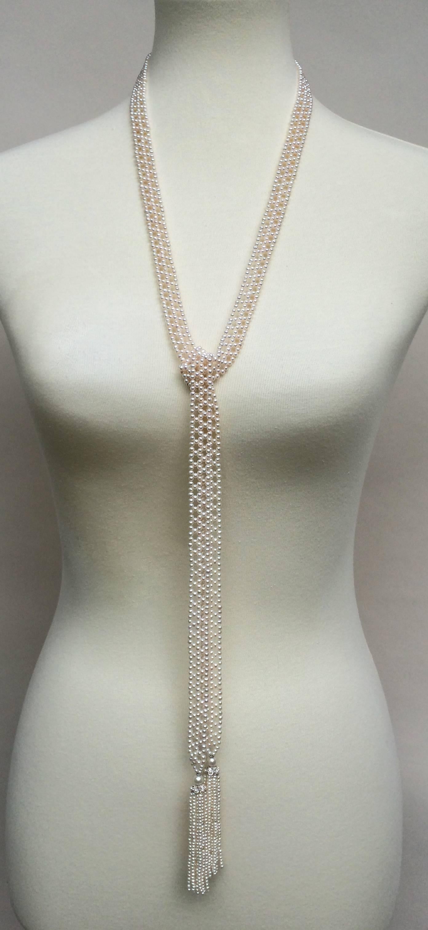 Marina J. presents a unique handmade sautoir necklace, made of small white 2- 2.5 mm pearls and woven into a complex, double lace-like design. The ends of the necklace taper into small pearls, and are complimented by white gold roundels. The lush