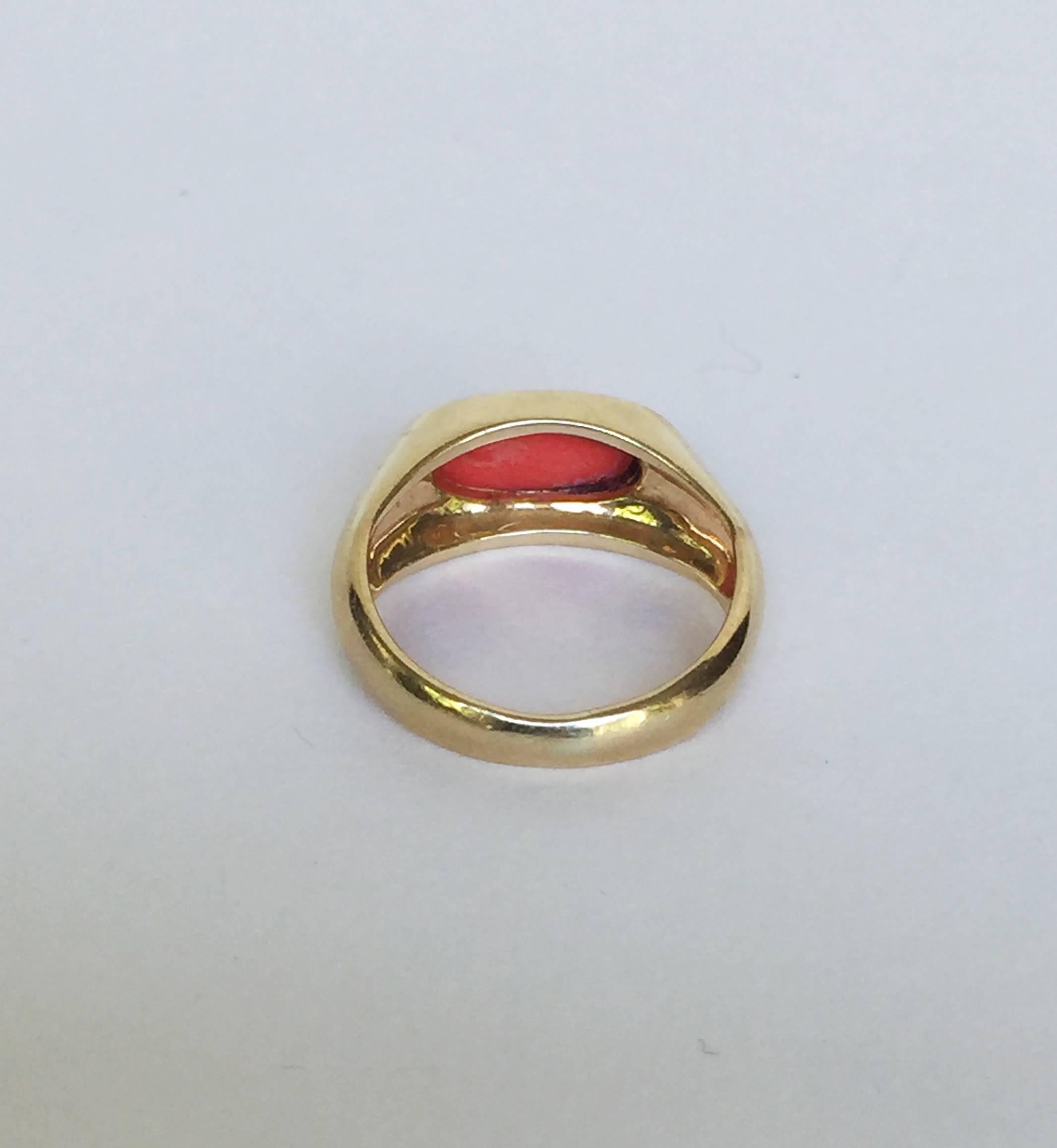 This simple and elegant pinky ring is original from the 1950s. The ring has a distinguished look. The coral center has a rich warm pink color accentuated by the 14k gold band.The size is 4.25