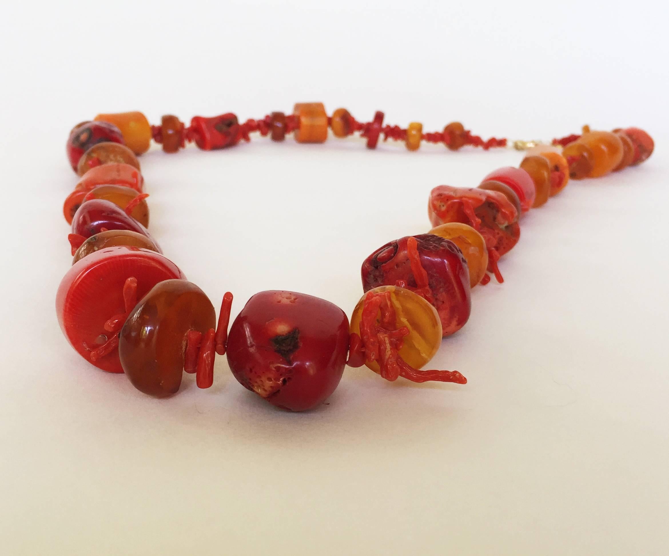 This statement necklace by Marina J is strung with graduated Middle Eastern coral and Russian amber beads, held together by a 14k yellow gold secured clasp. The necklace's large and authentic beads give the necklace a weighty look, but it is not