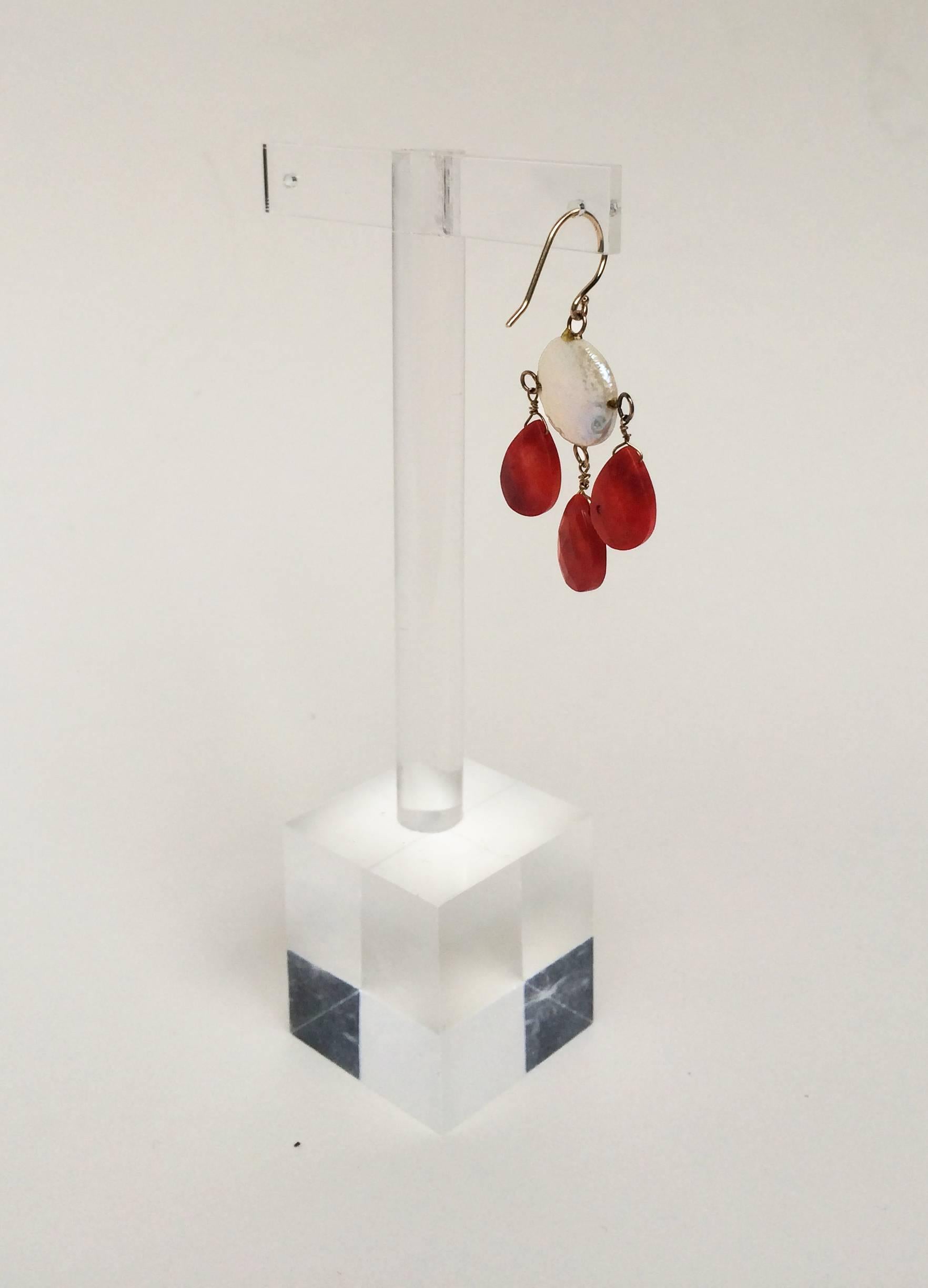 These minimalist earrings are simple in design, but elegant and striking with the rich red coral drop beads and glistening coin pearls. Highlighting the stones are 14k yellow gold wiring and hook. The earrings hang at 1.5 inches to accentuate the