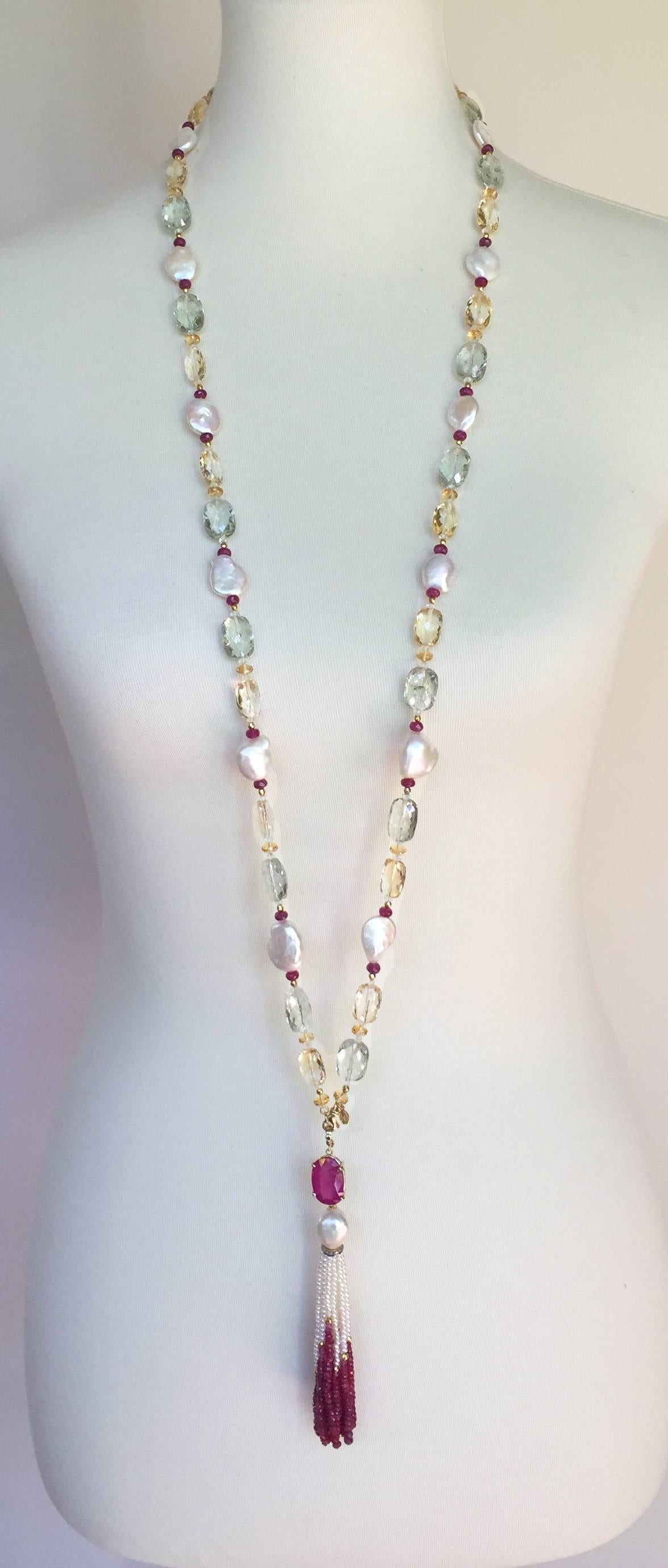 This vibrant sautoir is composed of pearl, citrine, and blue topaz beads accented by small ruby, aquamarine, citrine, 14k gold beads. The centerpiece of the sautoir is a tassel (5 inches)2800 with a large ruby and Baroque pearl with diamond
