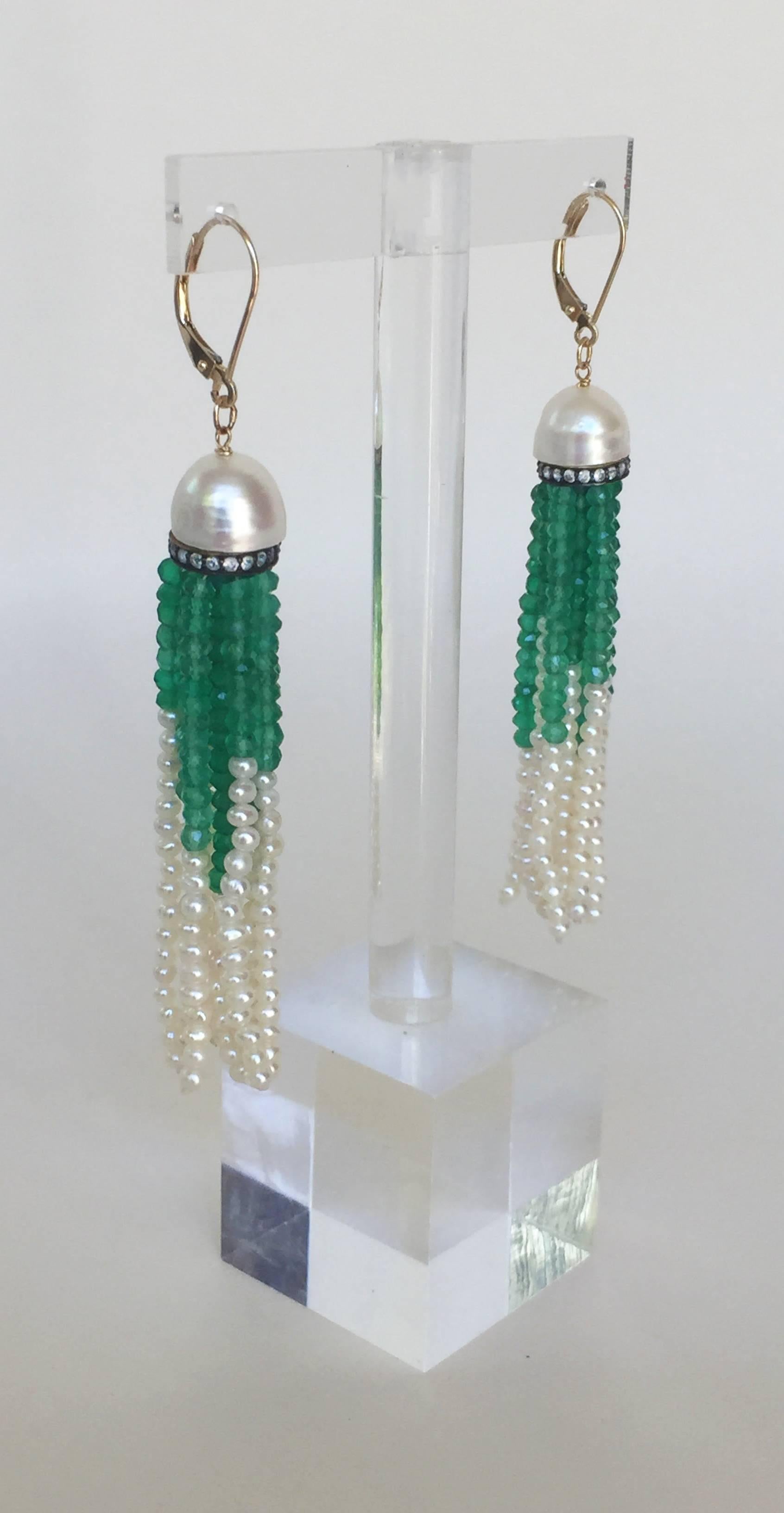 Striking One of a Kind pair of Earrings by Marina J. This pair of earrings feature two half cut Baroque Pearls displaying a great iridescent sheen, sitting atop Diamond encrusted roundels- from which vibrant and vivid faceted Green Onyx and Seed