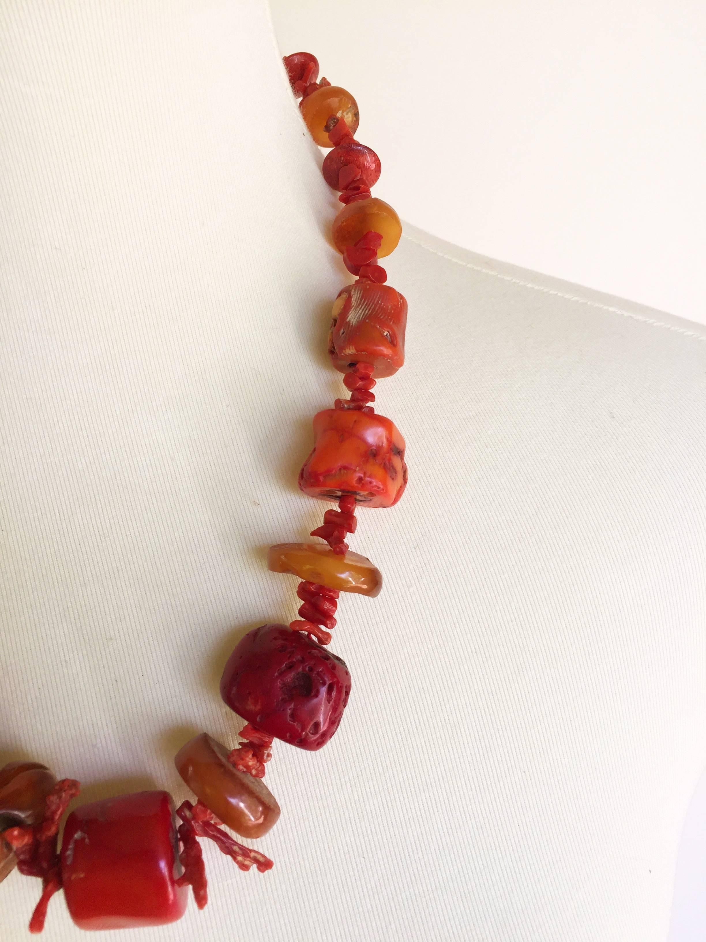 This statement necklace by Marina J is strung with graduated Middle Eastern coral and Russian amber beads, held together by a 14k yellow gold secured clasp. The necklace's large and authentic beads give the necklace a weighty look, but it is not too