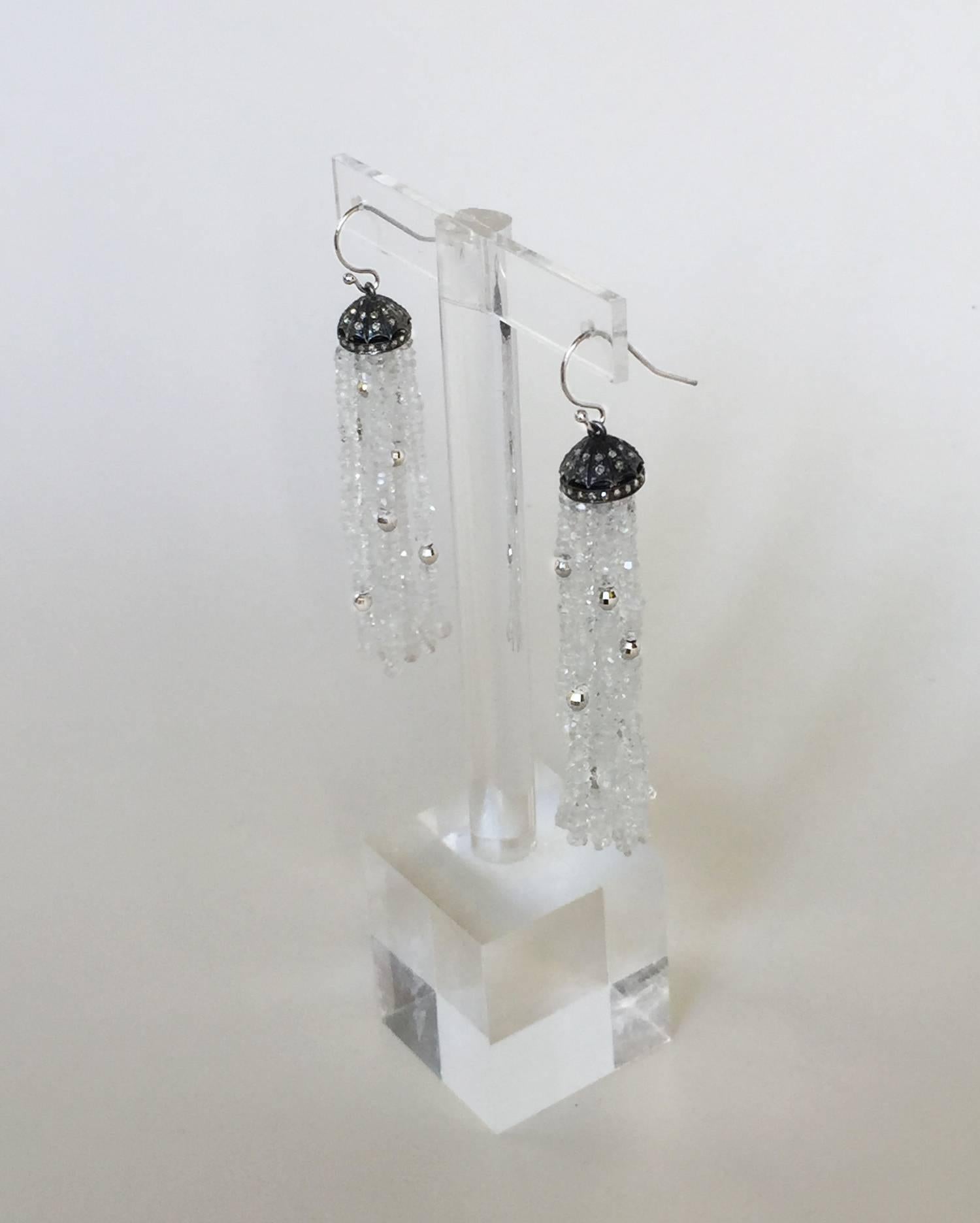 The white topaz with silver faceted beaded tassel glisten like fresh snow. The diamond encrusted sterling silver cup highlights the tassels perfectly. The earring hangs from 14k white gold hook at 2.5 inches. The ever slightly graduated tassels