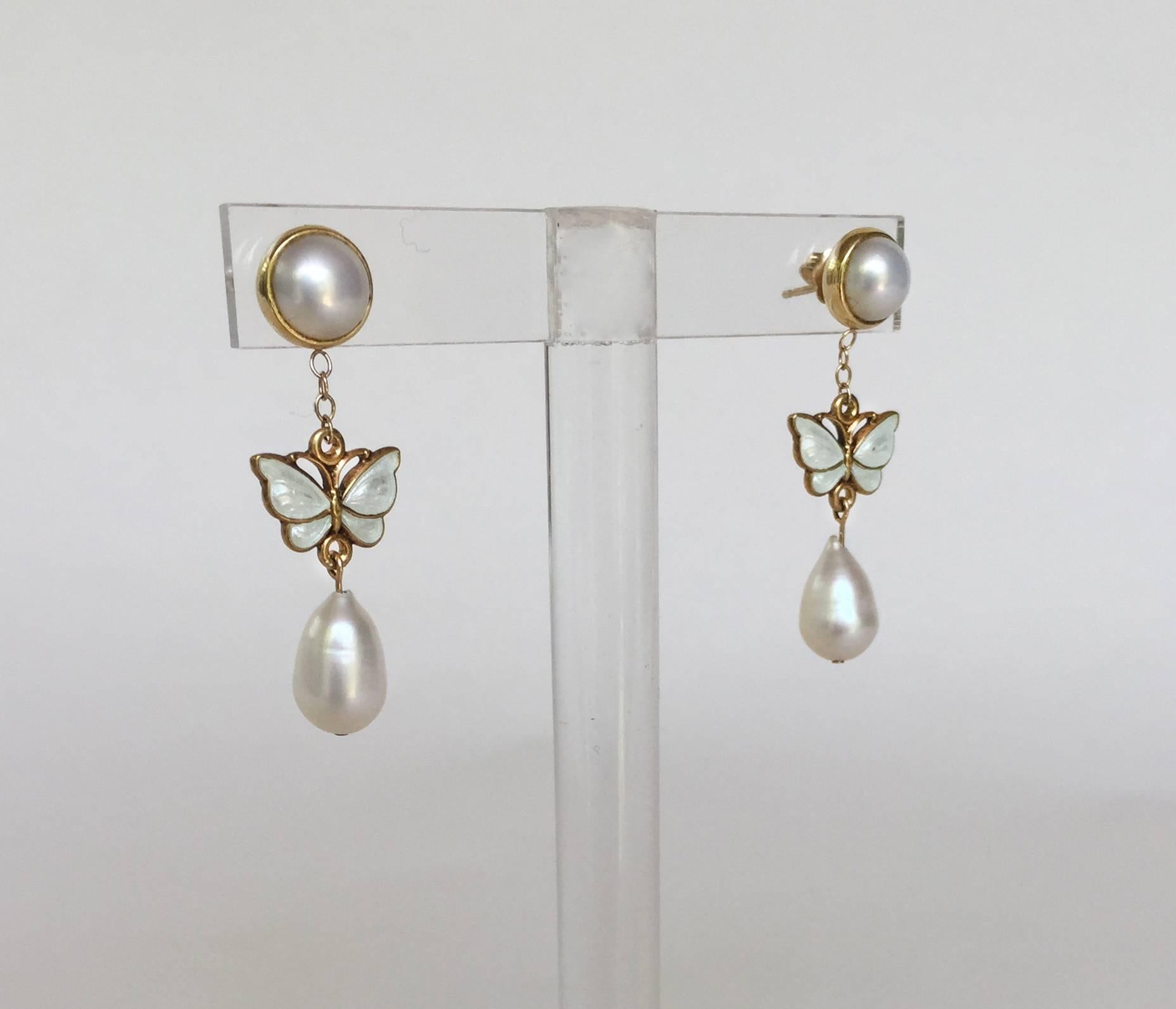 These small, but eye catching earrings have a beautiful white pearls and 14k yellow gold findings. The centerpiece of these earrings are vintage enamel butterflies, that almost look like they are flying dangling from the 14k yellow gold chain. They