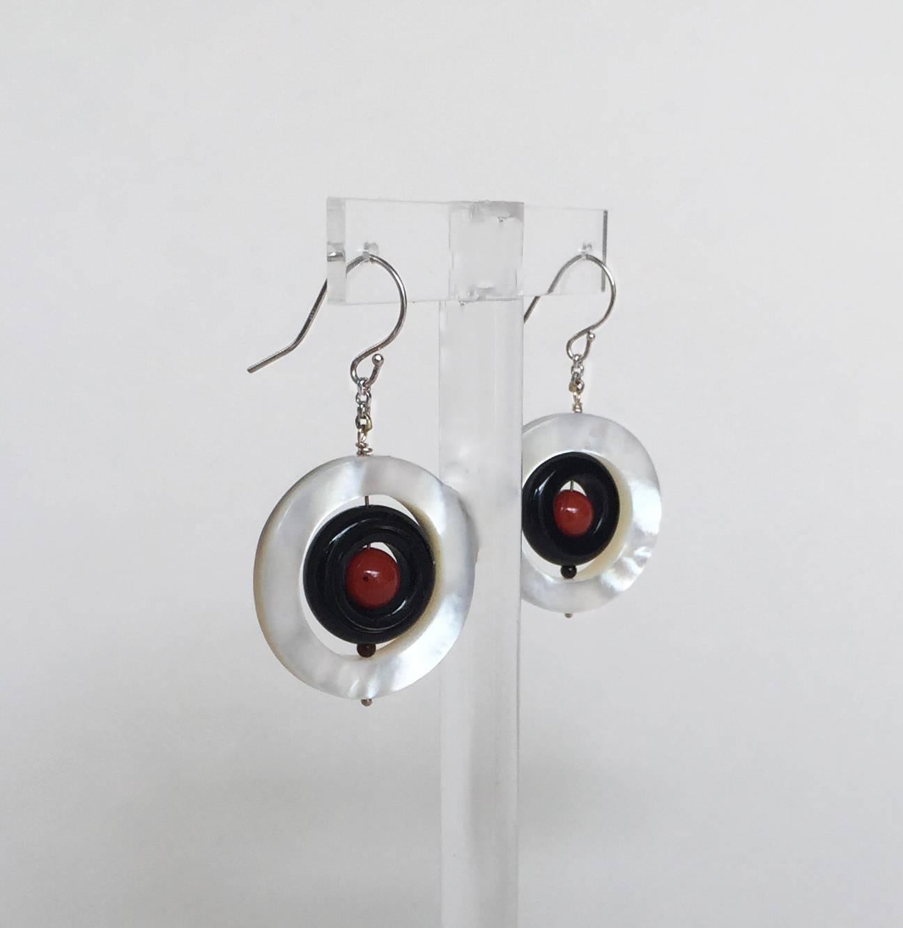 Natural coloration of the mother pearl ring shines and highlights the elegant combination of  the vibrant coral and black onyx. The beads hang on a 14k white gold chain and wire allowing the earrings to dangle more with movement. 