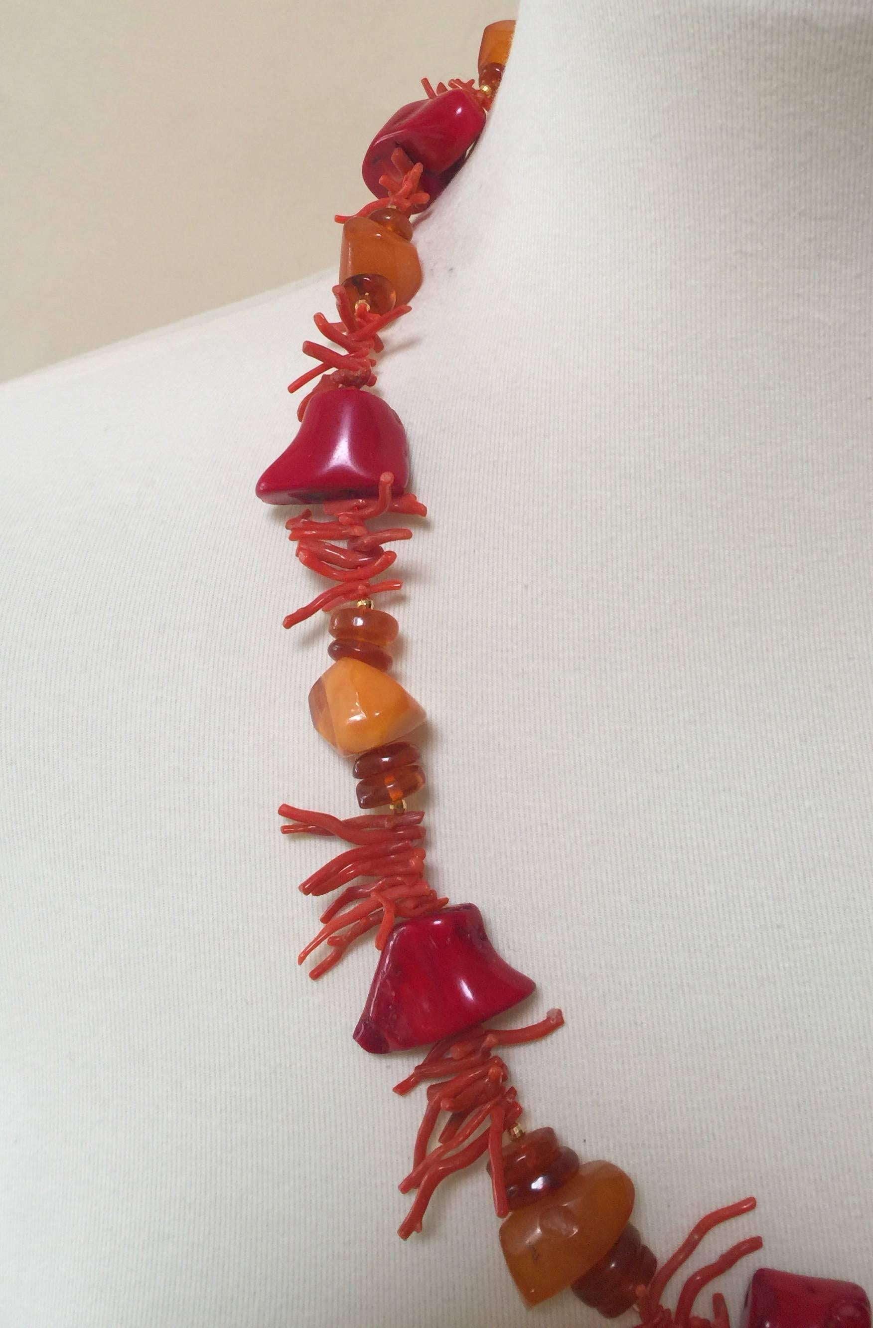 This necklace is composed of large asymmetrical coral and amber beads, carefully chosen to create a dynamic statement piece. The gold plated silver beads highlight the rich fiery colors of amber and coral beads. A secure and easy to use gold plated
