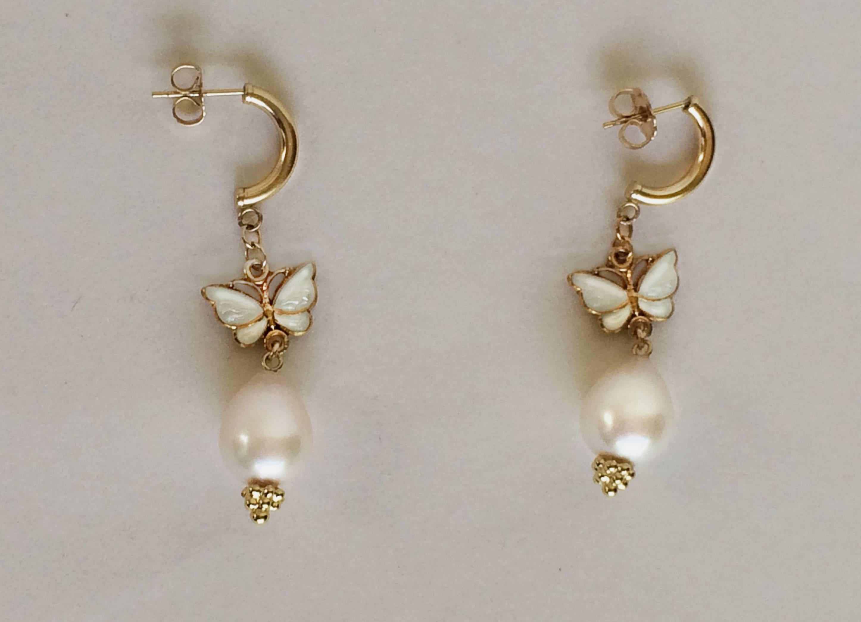 These earrings are perfect for a beautiful summer day out.  A vintage butterfly (c.1950s) with fine white enamel hangs from a 14k gold earring and finished with a large drop shaped pearl. The earrings hangs 1.5 inches, highlighting the face and