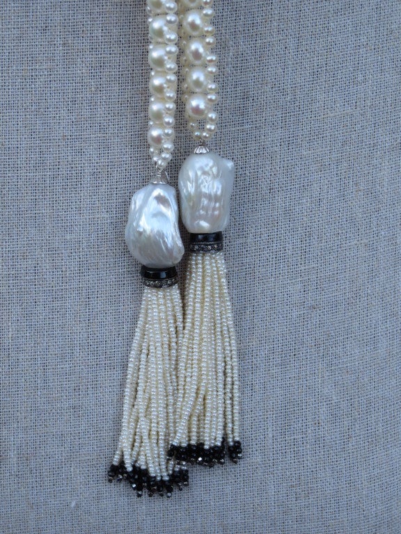 Beautiful and intricately woven handmade rope sautoir made of 6.5mm and 2.5mm high quality white pearls. Tassels are made of large Baroque pearls accented with onyx, silver and diamond rondelles.  Each pearl tassel strand is accented with onyx beads
