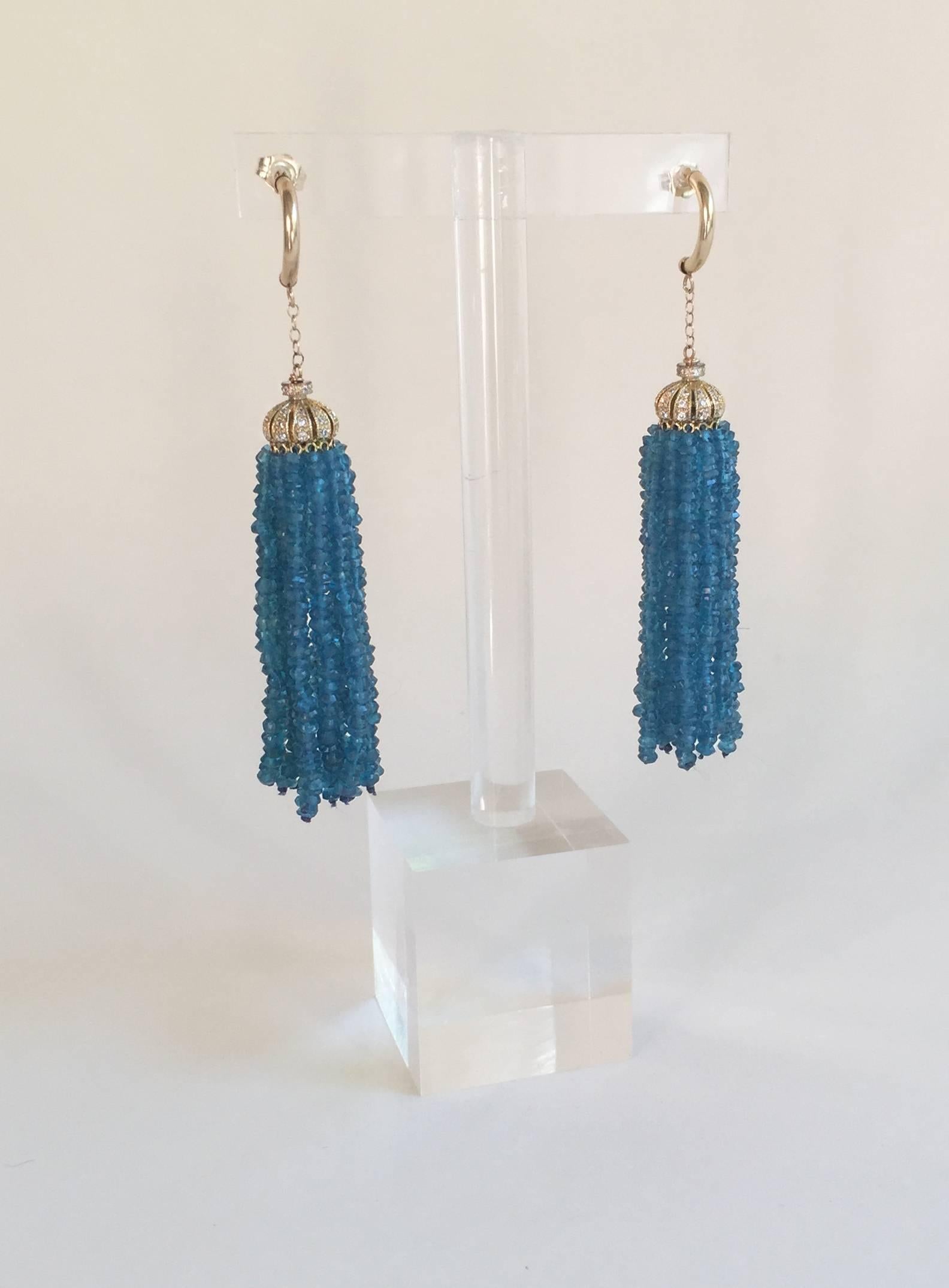 These vibrant blue London Blue Topaz tassel earrings elegantly frame the face and dance with the your movements. The earrings are crowned with Silver-Gold Plate and Diamond encrusted cups, completed with 14k yellow finishing. These earrings hang at