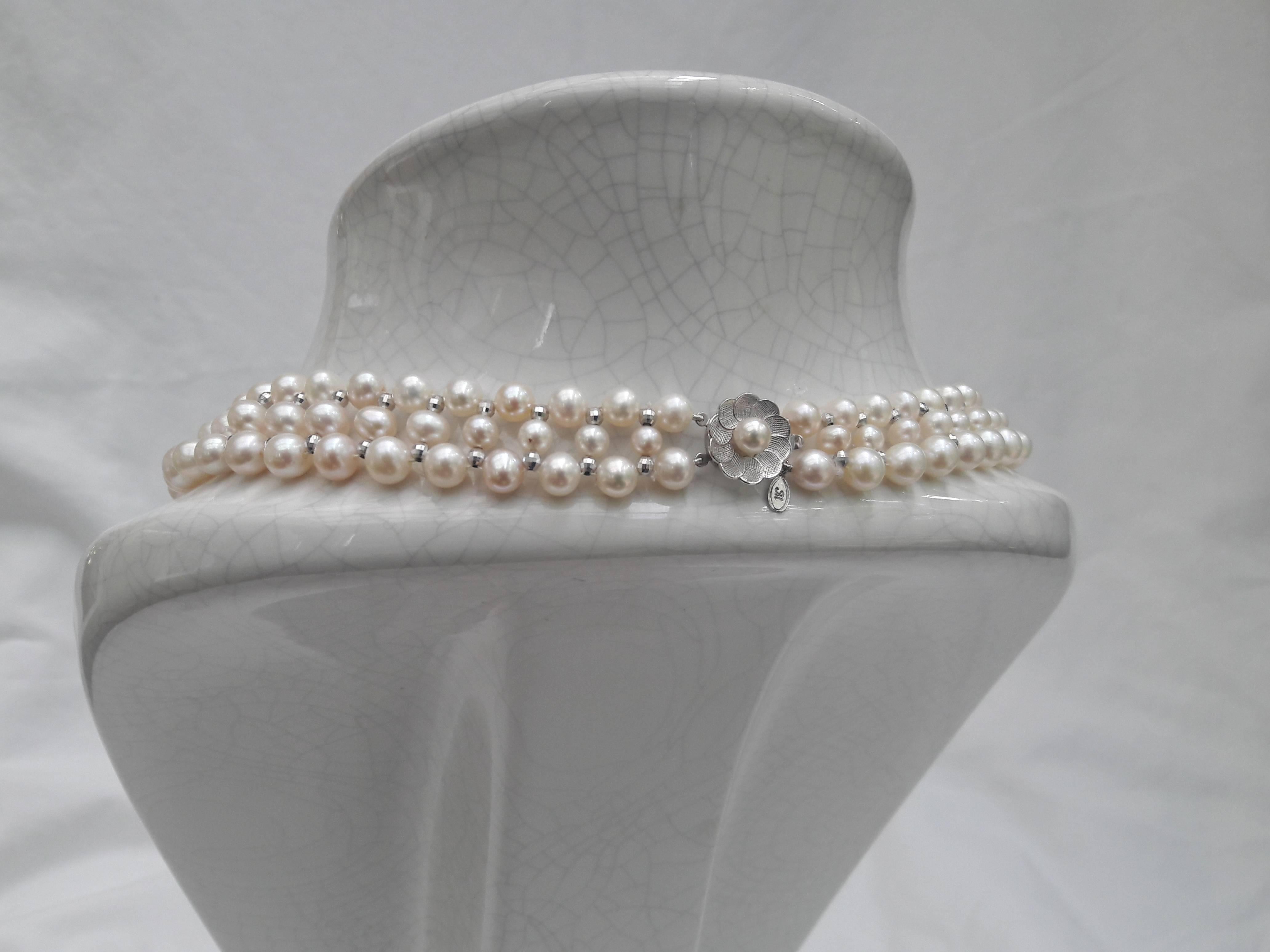 This intricately hand woven necklace is made of 5-6.5 mm cultured pearls with 14 k white gold faceted beads. Necklace is tapered in design to fit perfectly along the curve of the neckline.

Locking clasp is made of 14 k white gold and styled as a