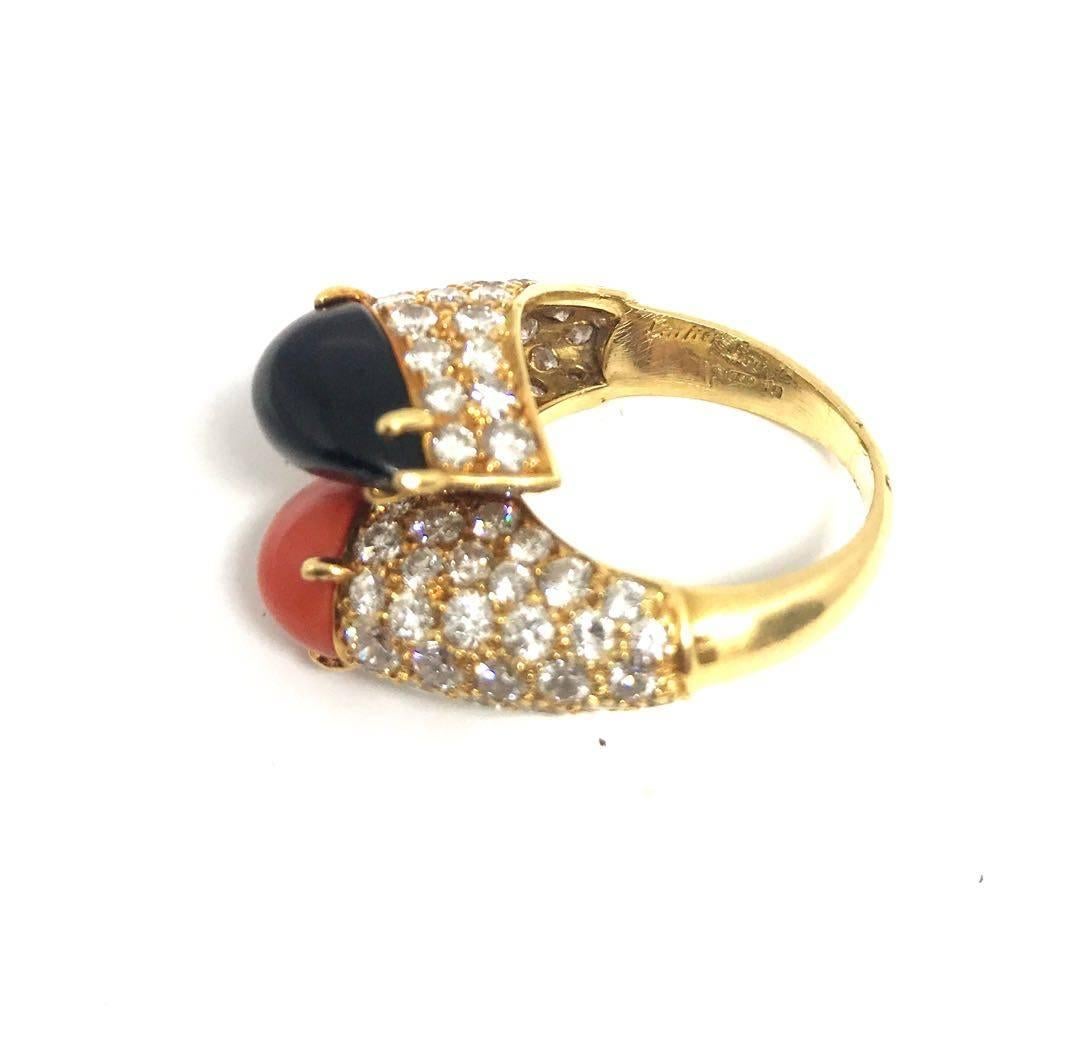 This wonderful vintage diamond ring features orange coral and onyx cabochons. Sophisticated yet classic this ring would complement any casual look or would look amazing at a cocktail party.The ring is signed by Cartier and there is approximately