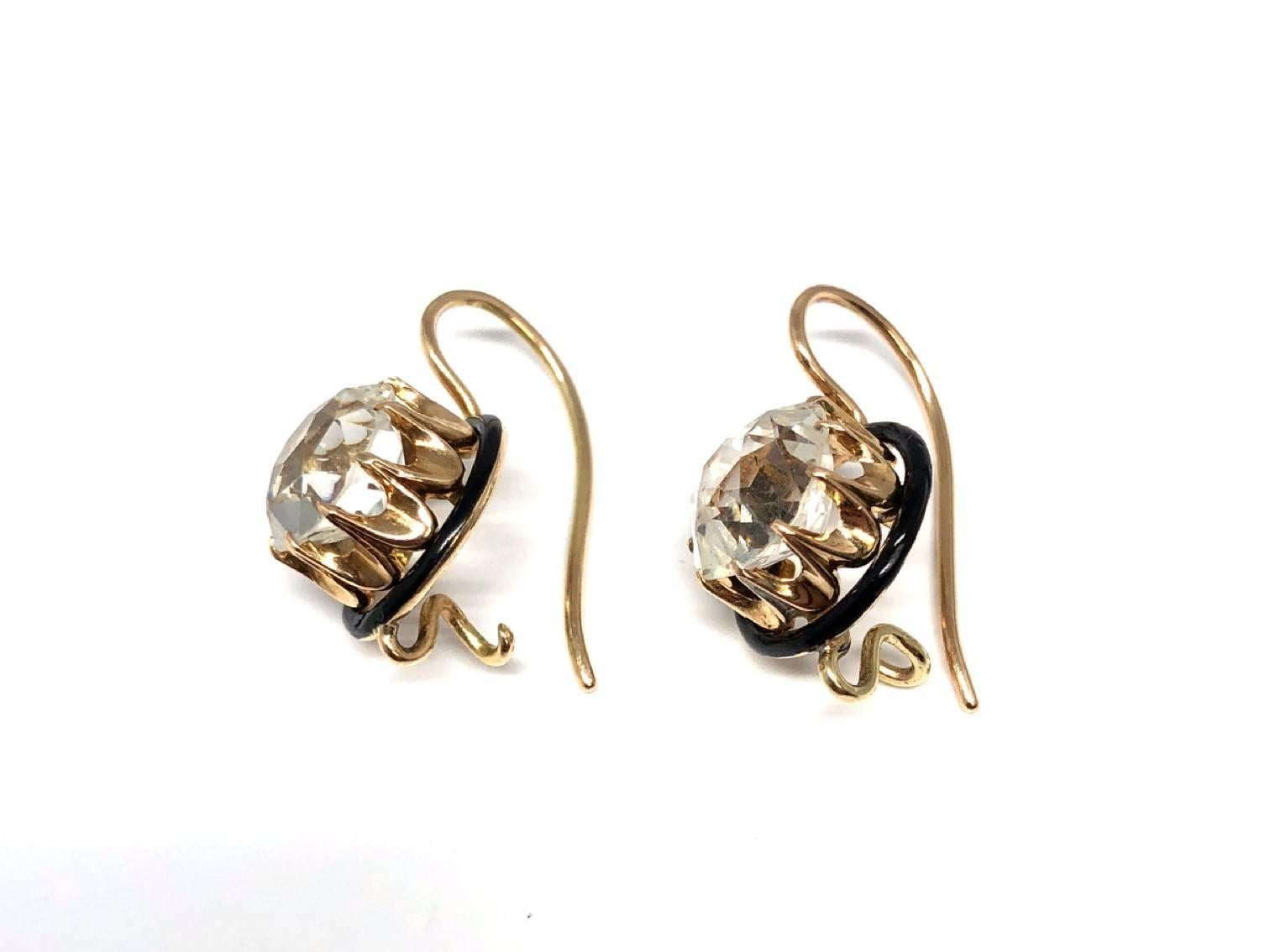 White Topaz stone framed in black enamel and gold. Thin golden wiring encases the stone, beautifully worked around it and framed in black enamel. Classic and simple design creates an elegant set of earrings.