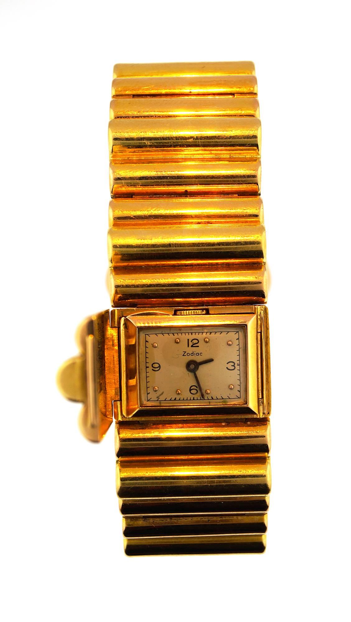 Fantastic 18K yellow gold tank watch with a Zodiac movement. This beautiful and quite rare retro bracelet is set with 11 gold links. One of which hides a watch dial. This transforms the watch into a beautiful piece of retro jewelry. 
The watch