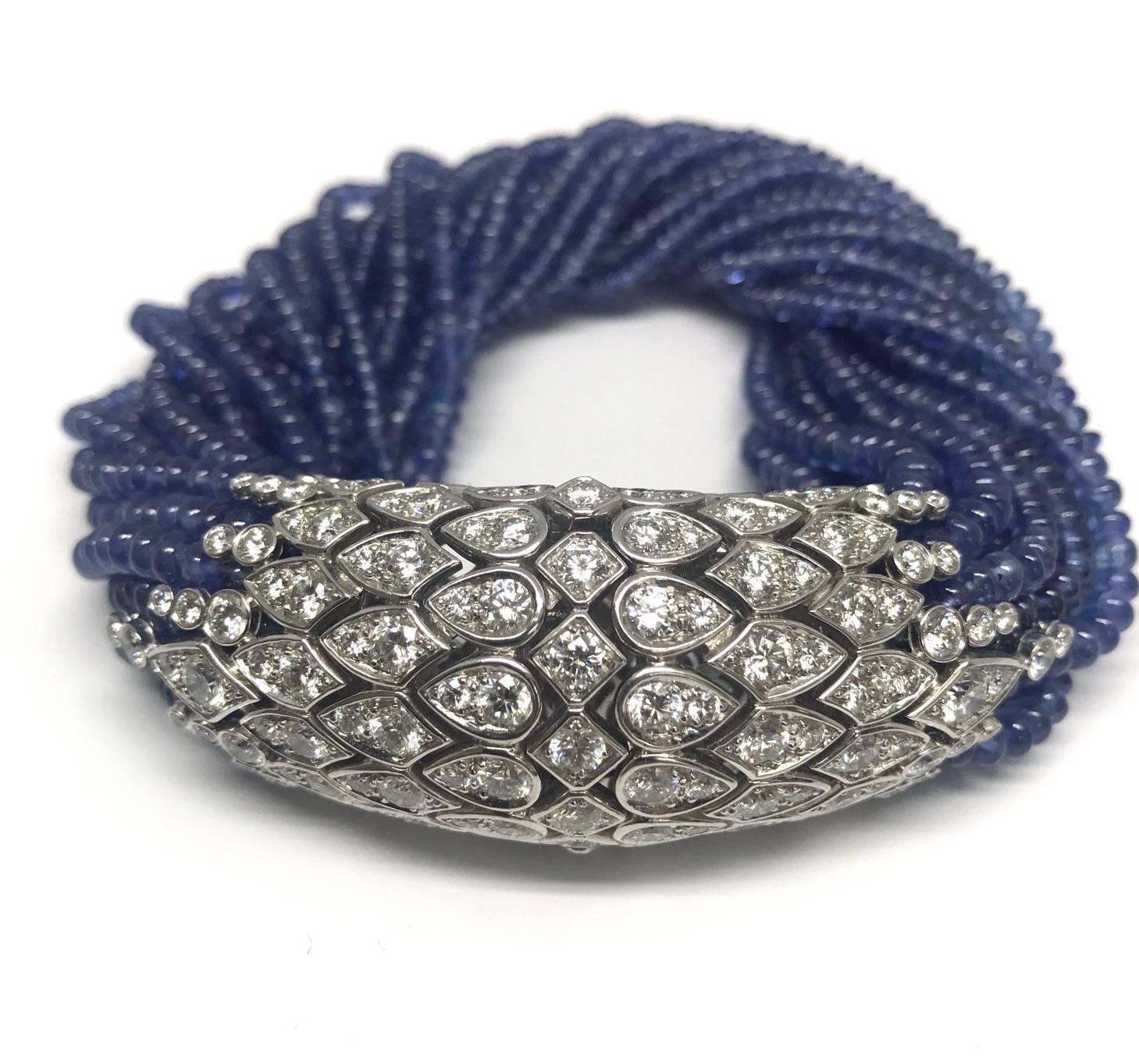 This unique twist bracelet is composed of 21 strands of sapphire beads, the scale-like terminals are set with round diamonds  E-F color weighing approximately 8.60 carats, the length of this bracelet is 7¼ inches.
The piece is signed by Cartier,