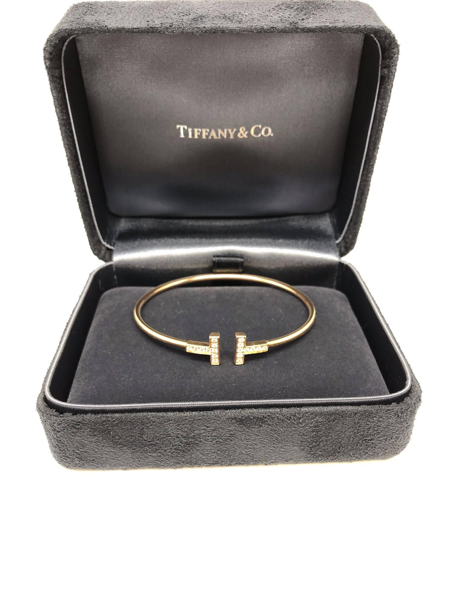 Tiffany & Co. iconic T design bracelet, the T housing brilliant round diamonds. The slim 18k gold band is made to flex and bend back into shape after slipping on the wrist. 

Inspired by New York architecture, T designs are strong and dynamic just