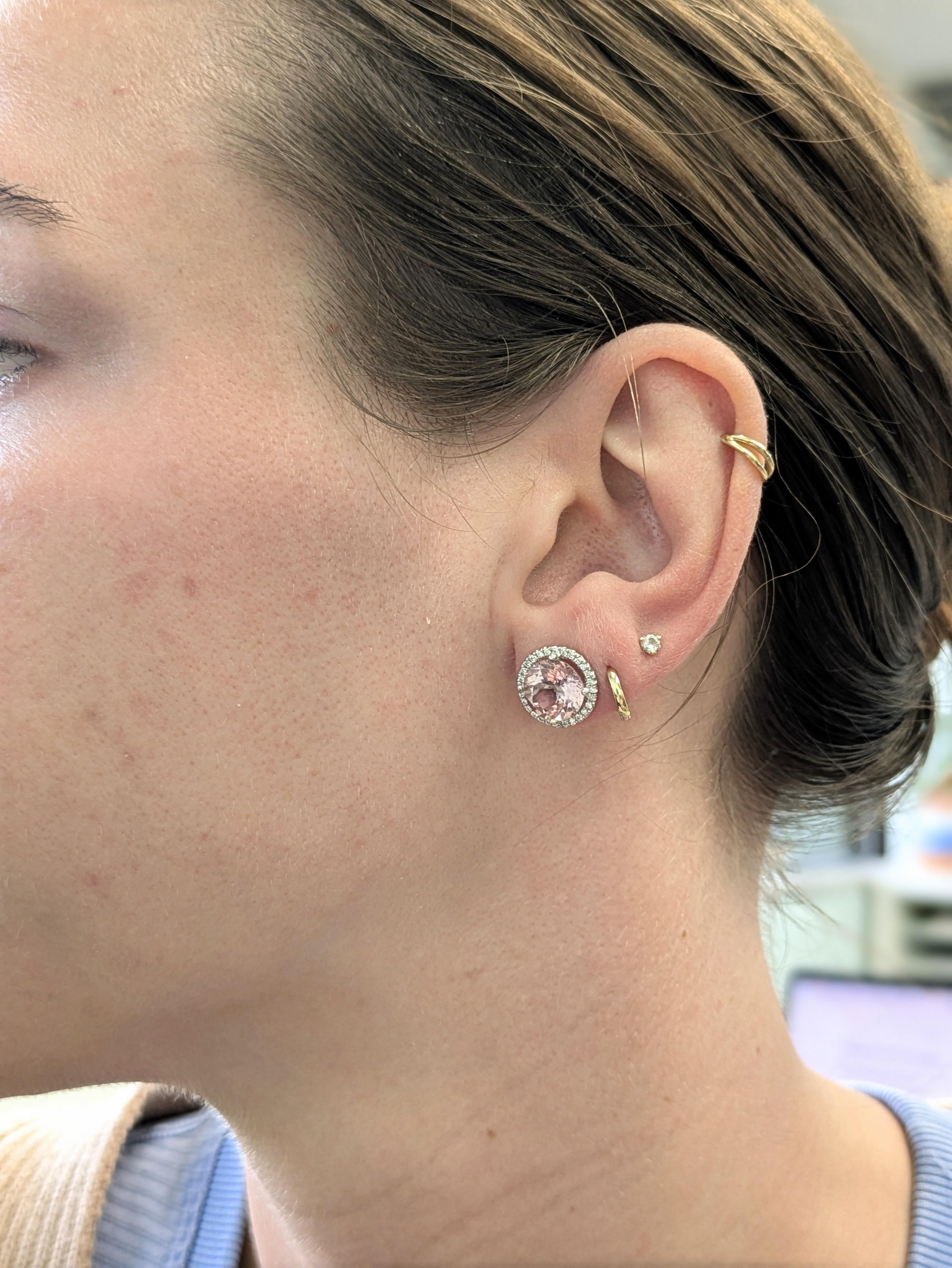 Delicatamente femminili e lussuosi, questi orecchini a perno presentano gemme rotonde di morganite brasiliana da 5,32 carati abbracciate da una scintillante aureola di diamanti naturali. Realizzati in oro bianco massiccio 14 carati, sono il regalo