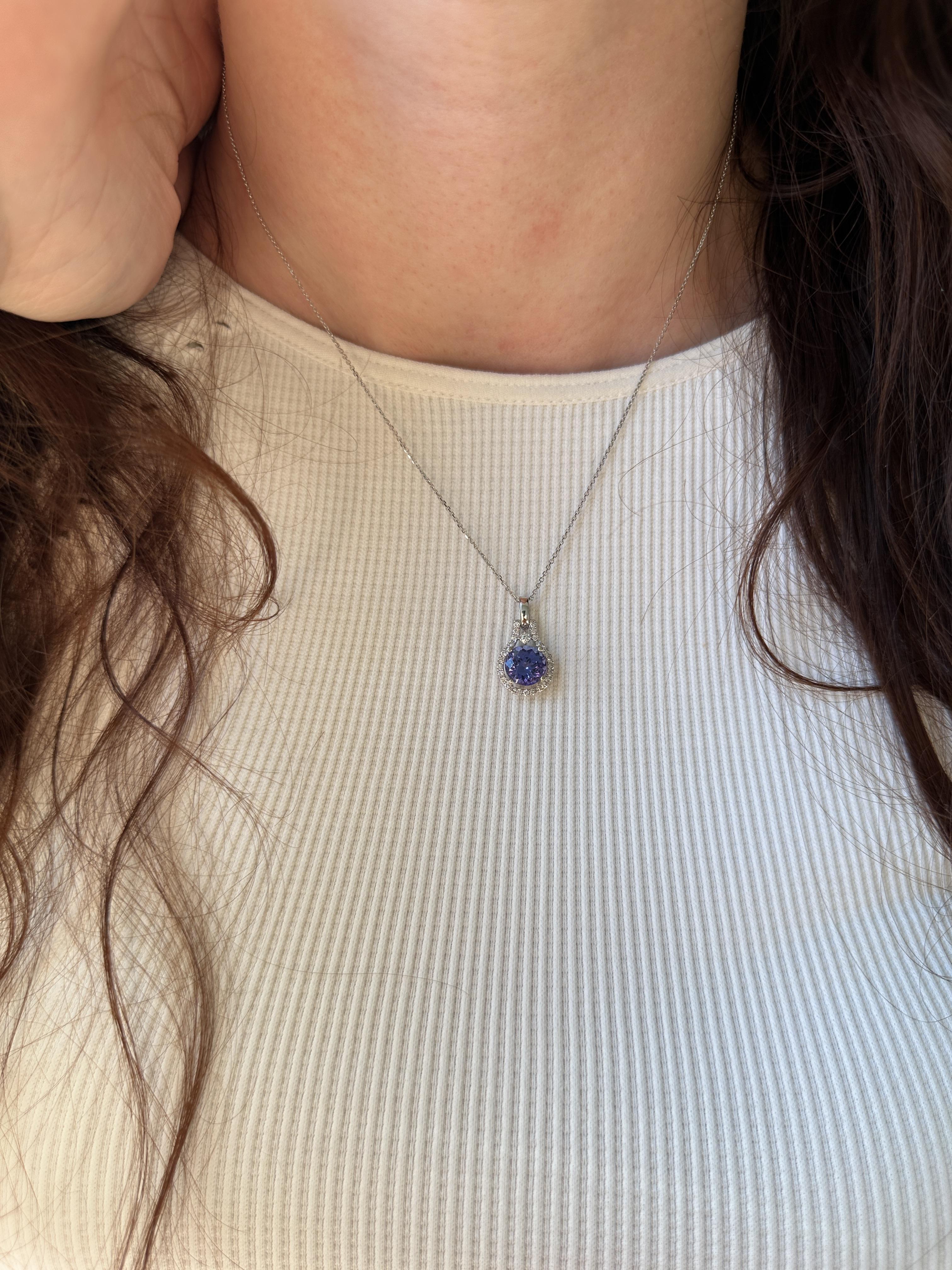 C'est l'heure des compliments. Cet adorable pendentif est orné d'une tanzanite ronde de 2,16 carats brillante, entourée d'un halo de diamants miniers étincelants. Fabriqué en or blanc massif 14 carats, c'est le genre de pièce délicate qui n'a rien