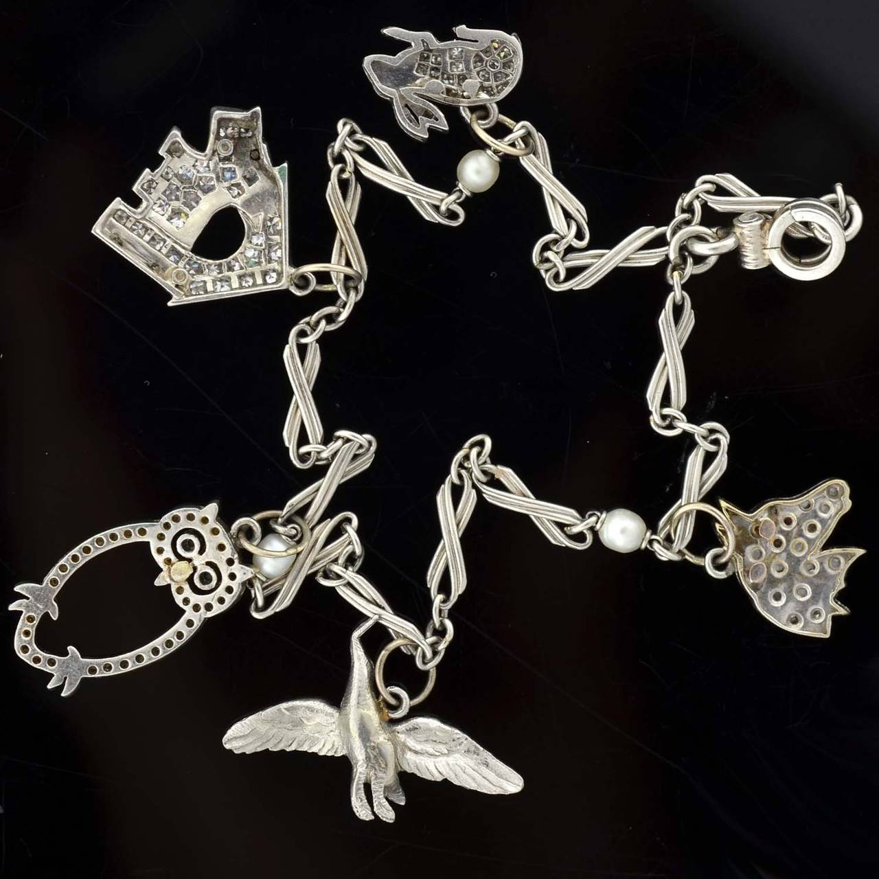 Art Deco Emerald Diamond Platinum Multi Charm Bracelet at 1stDibs