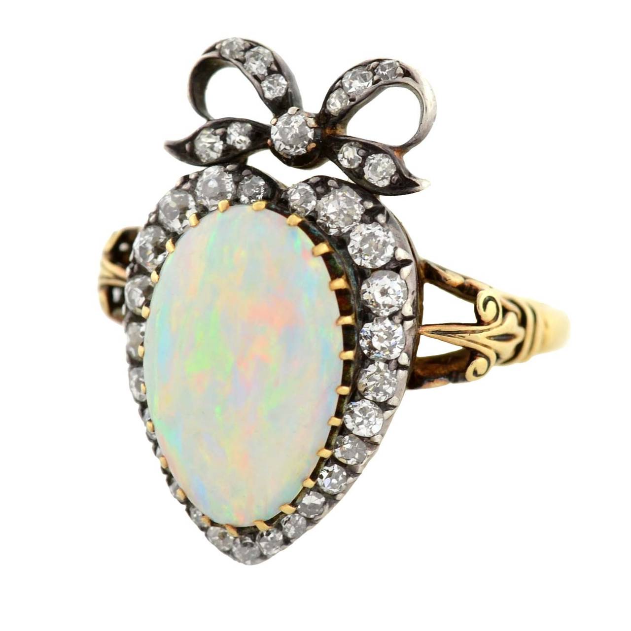 A very unusual opal and diamond ring from the Mid Victorian (circa 1870) era! This exquisite ring holds an opal cabochon at the center of a sterling-topped 18kt yellow gold mounting. A gorgeous heart-shaped diamond halo surrounds the opal cabochon,