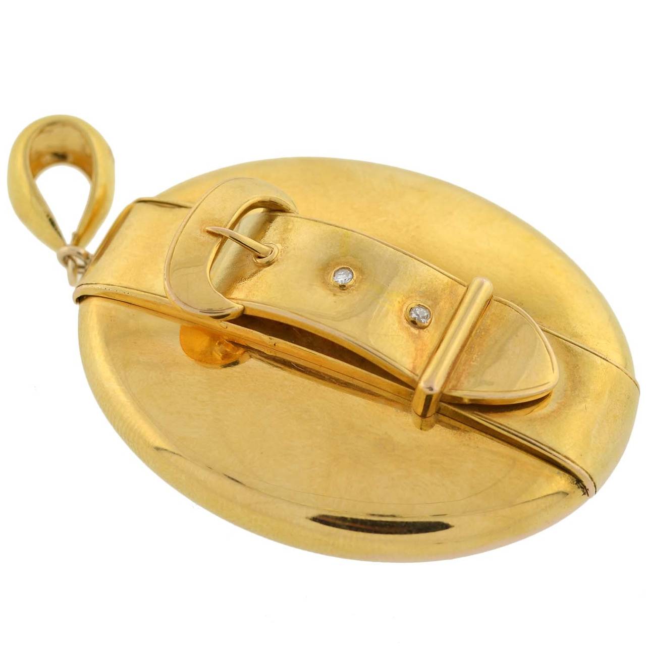 A delightful gold buckle locket from the Victorian (circa 1880) era! This beautiful oval-shaped piece is made of 14kt yellow gold and has a fabulous 3-dimensional buckle that lies vertically, from the top to the bottom. The buckle has 2 small old