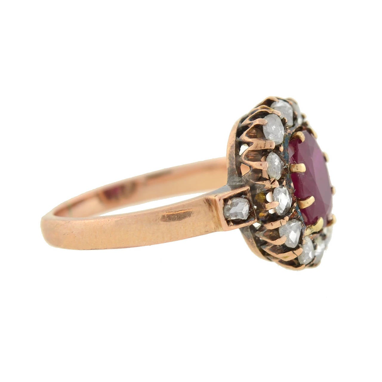 An absolutely gorgeous ruby and diamond ring from the Late Victorian (ca1900) era! Made of 14kt rosy yellow gold, the ring holds a natural oval cut Burmese ruby at the center, surrounded by 14 sparkling old Rose Cut diamonds. The ruby weighs 1.51ct