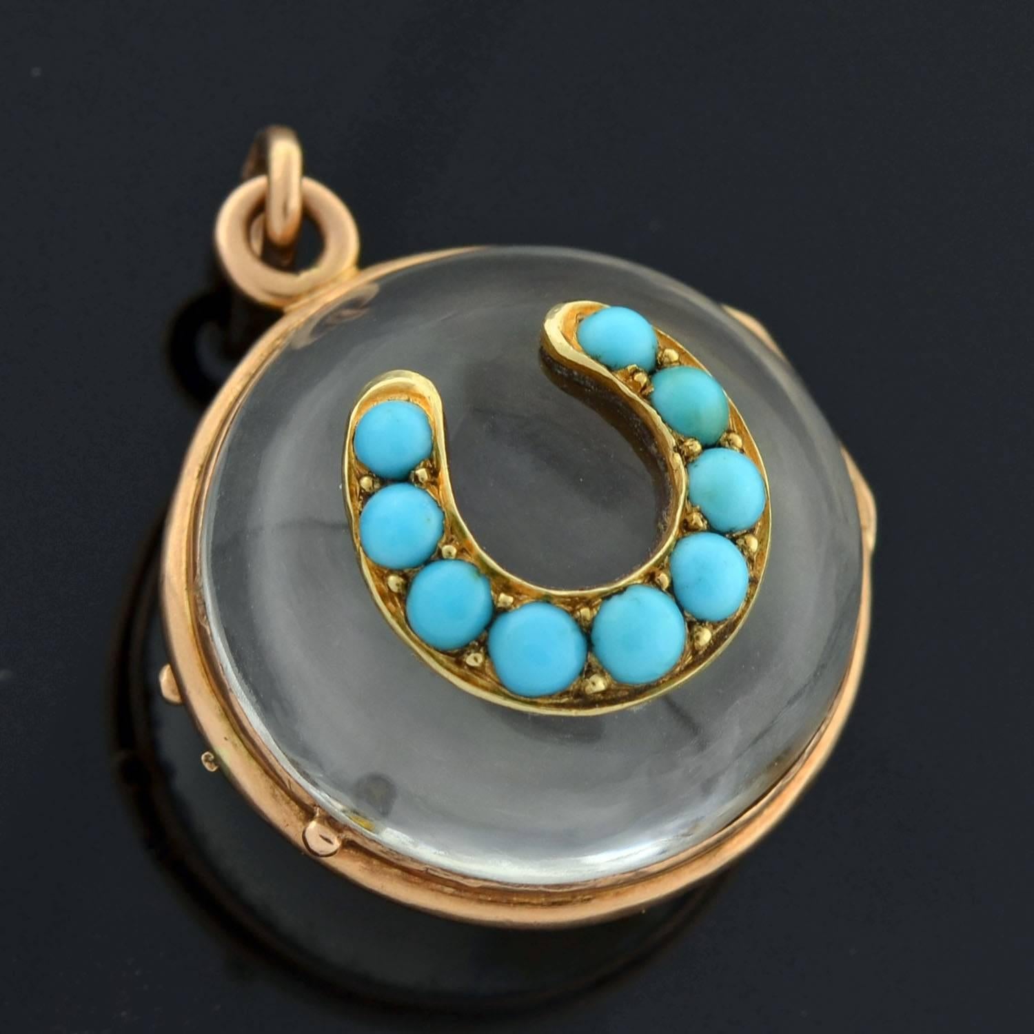 A beautiful and unusual horseshoe locket from the Victorian (ca1880) era! This spherical locket is carved from rock quartz crystal and is set in 14kt yellow gold. At the center is a lovely turquoise horseshoe motif! The smooth, clear rock quartz